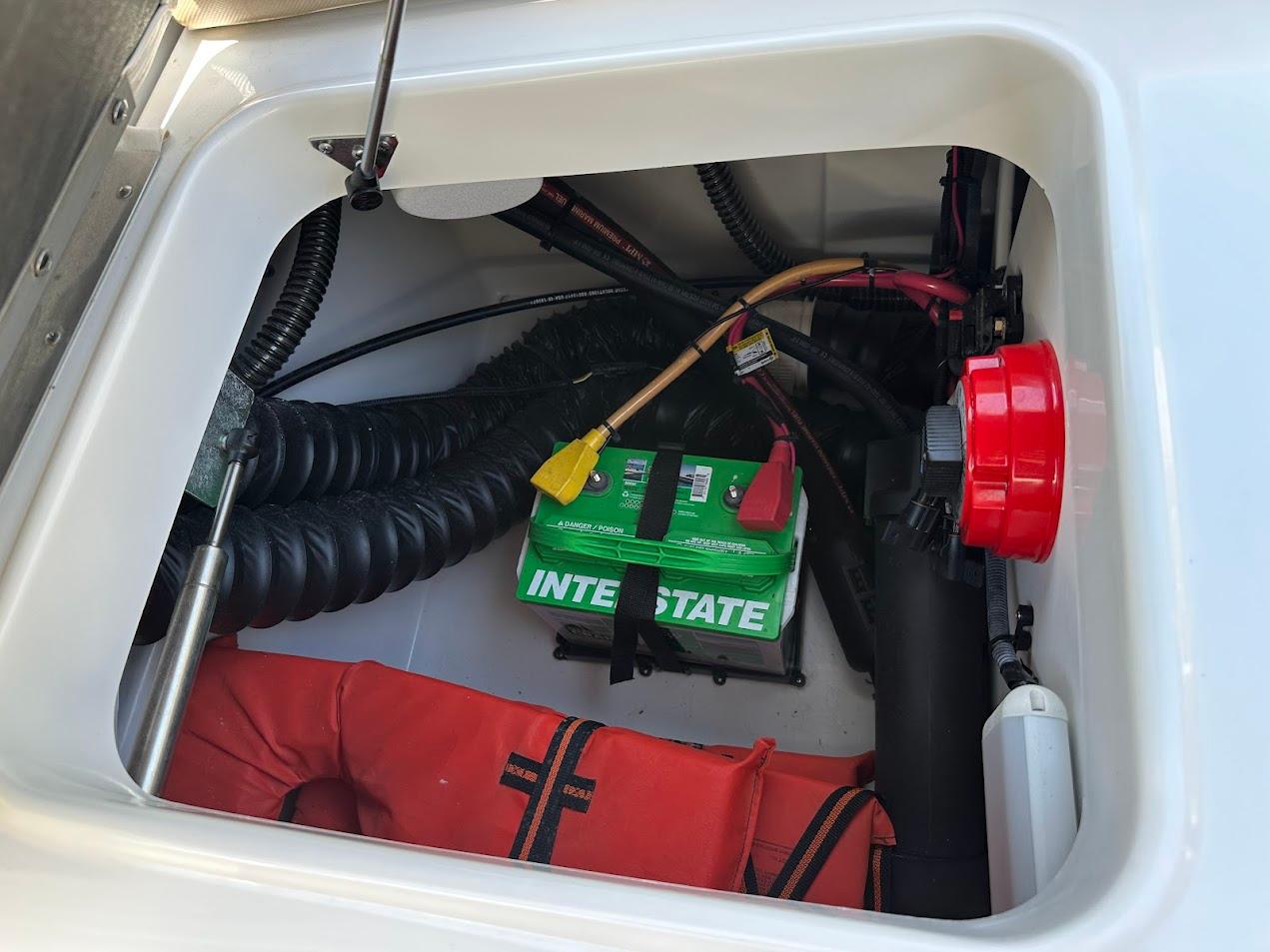 2019 Crownline 235 SS boat compartment with battery, wiring, and life jacket.