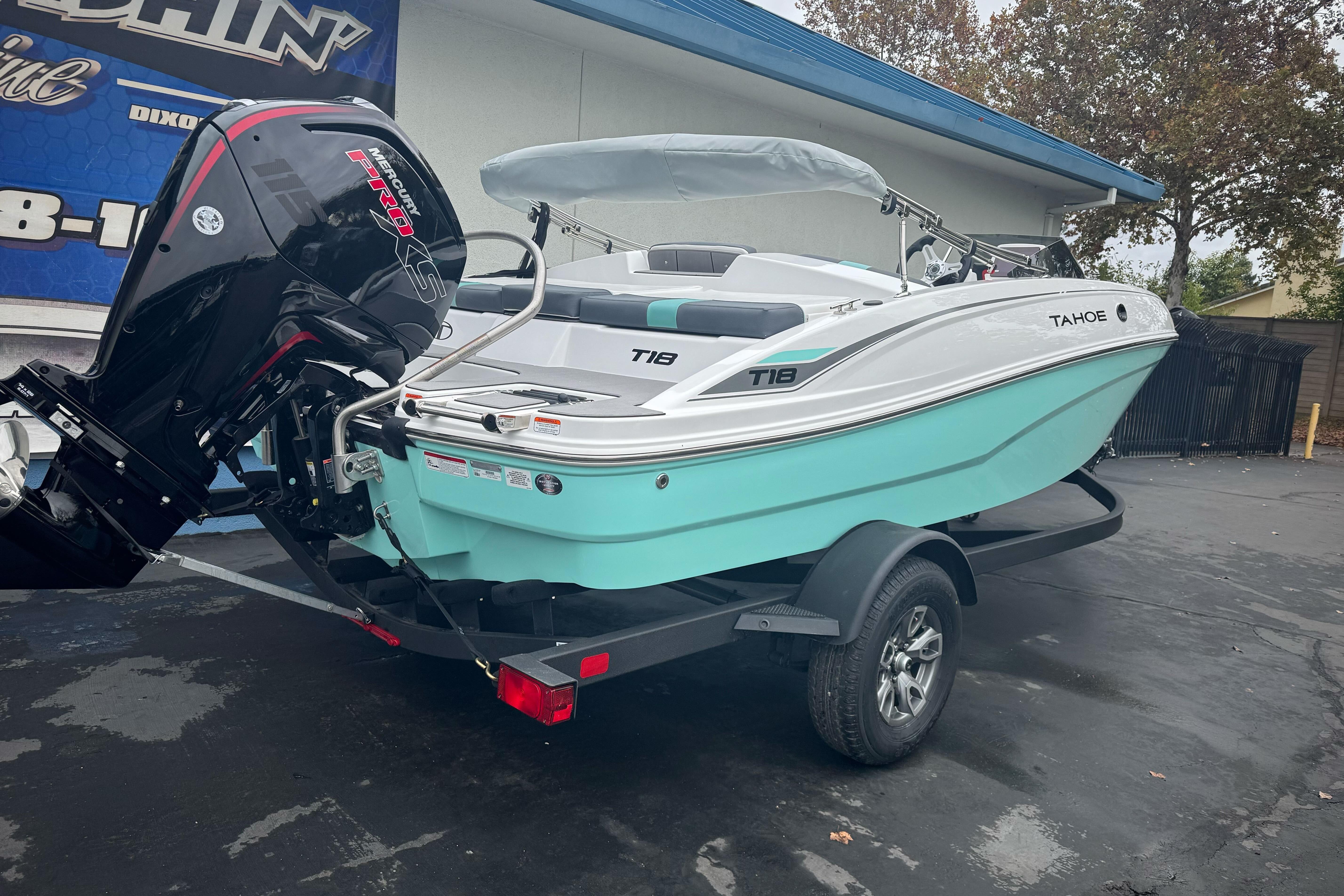 2026 Tahoe T18 boat on trailer with Mercury engine, parked outdoors.