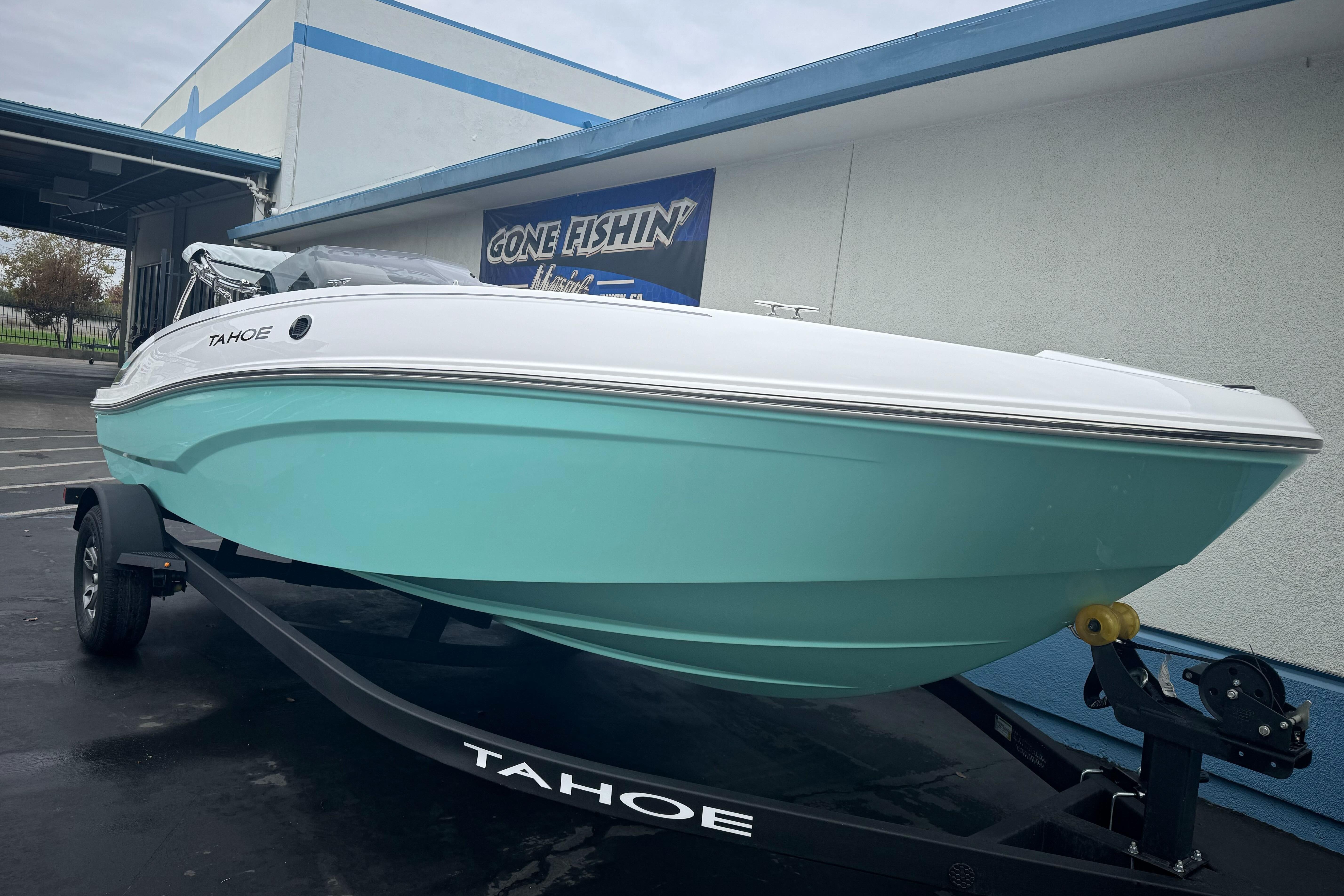 2026 Tahoe T18 boat on trailer, mint green hull, parked outside a building.