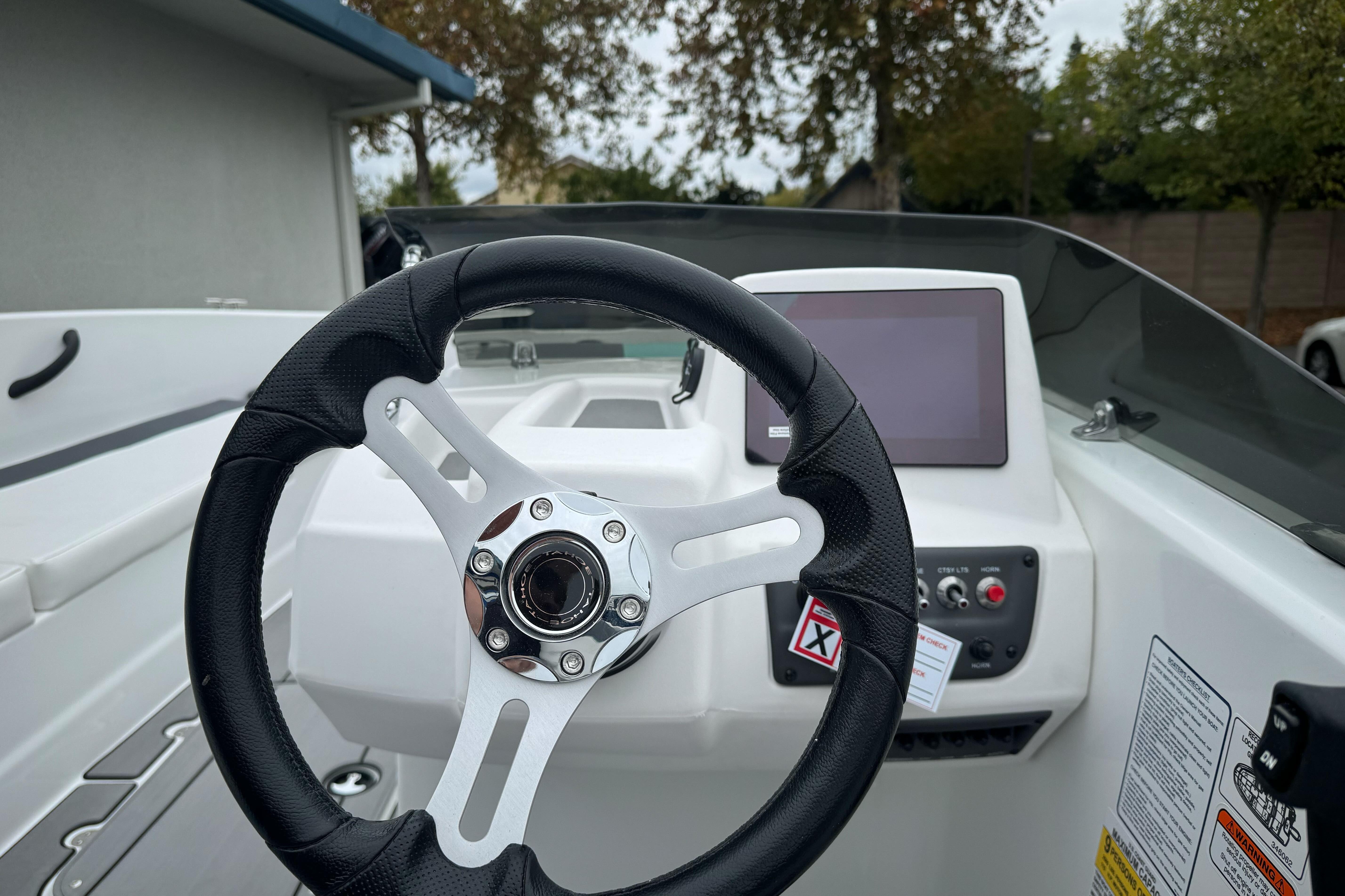 Steering wheel and dashboard of 2026 Tahoe T18 boat, featuring modern controls and display.