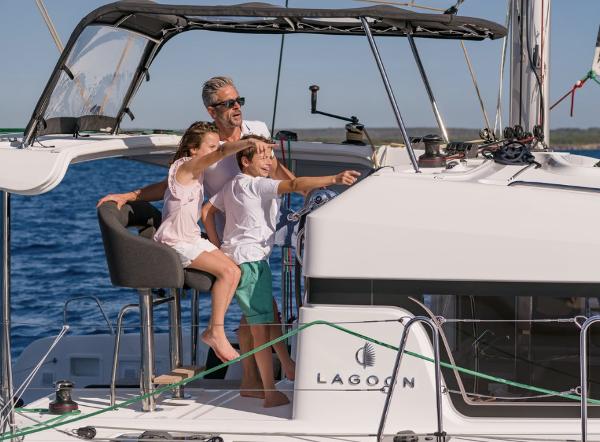 Family enjoying sailing on a 2020 Lagoon 40 catamaran in sunny weather.
