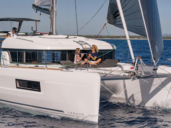 2020 Lagoon 40 catamaran sailing with passengers on deck, enjoying the ocean view.