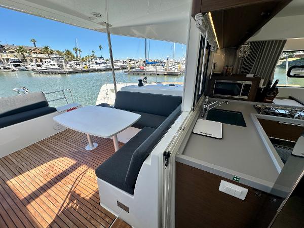 Modern Lagoon 40 catamaran interior with kitchen and seating area, docked at marina, 2020 model.