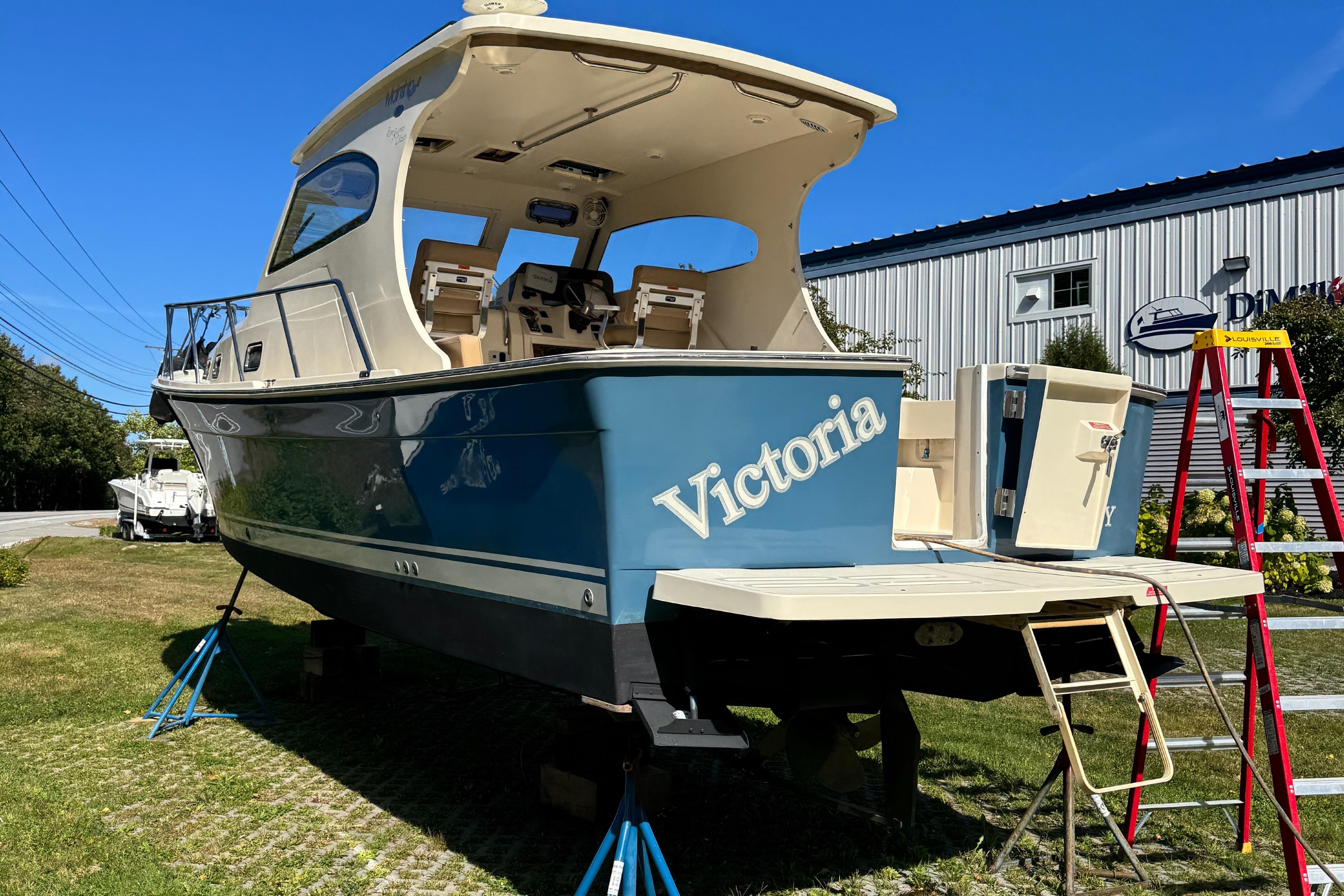 2006 Mainship Pilot 30 Sedan boat named Victoria on display outdoors.