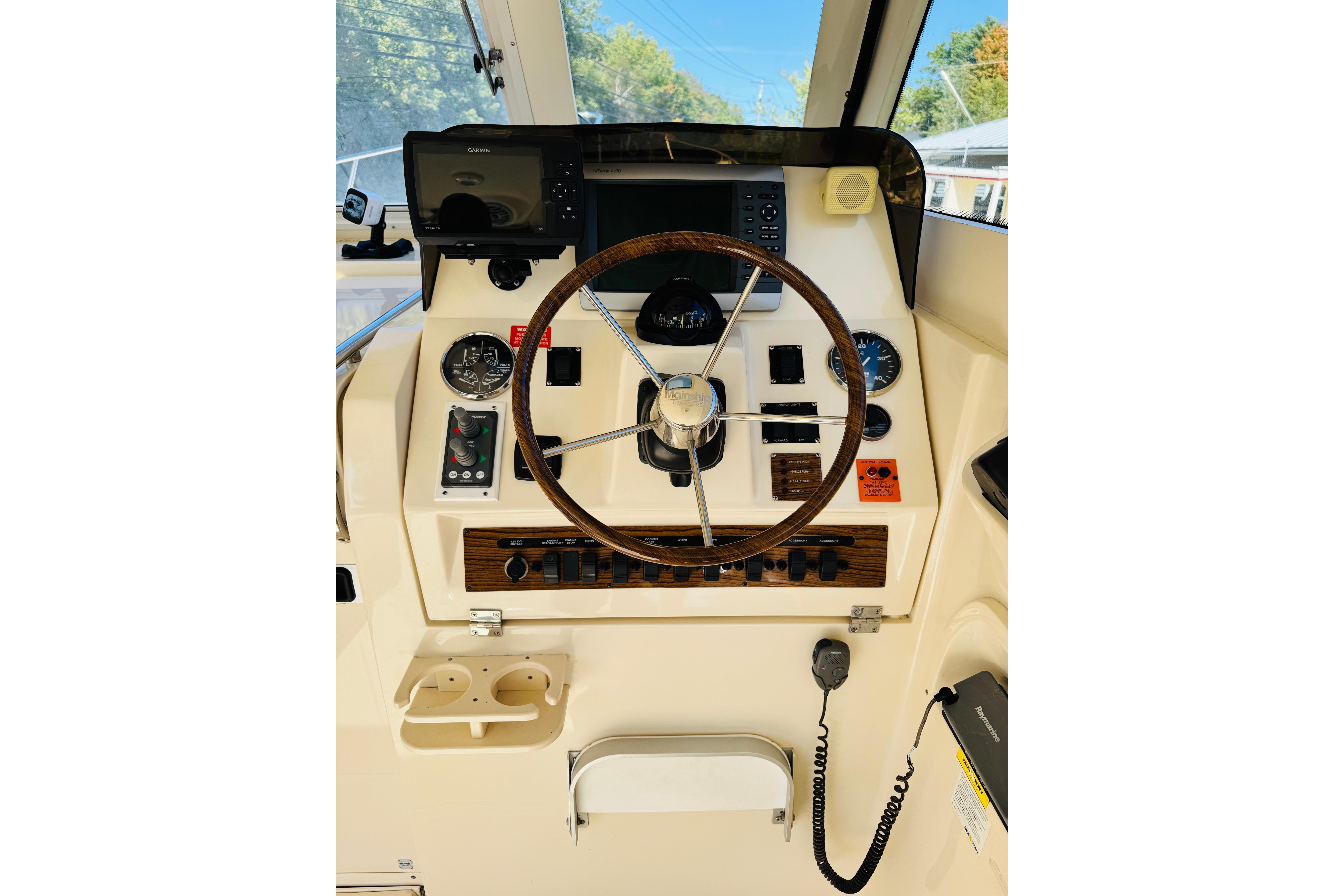 2006 Mainship Pilot 30 Sedan helm with steering wheel and navigation controls.