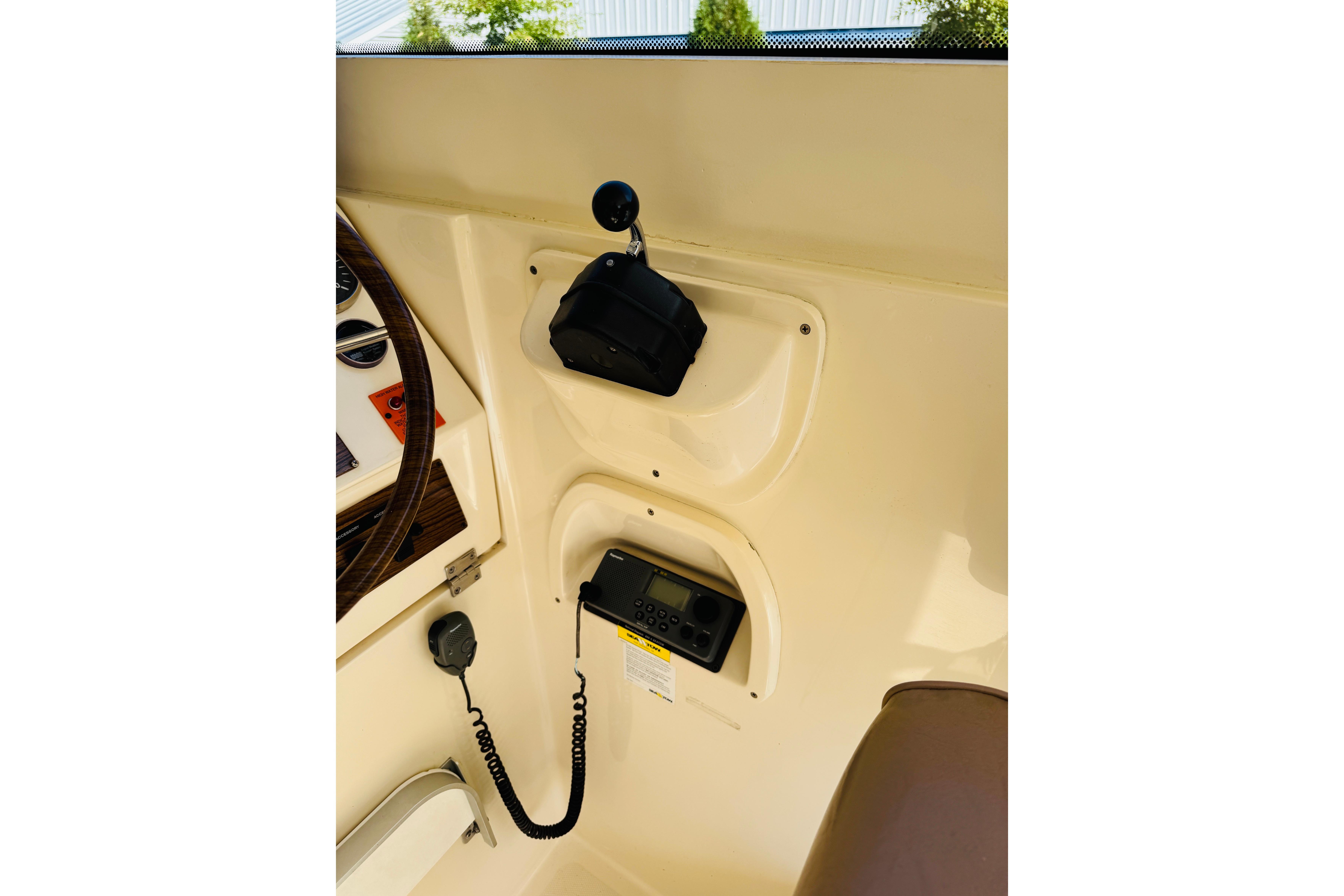 2006 Mainship Pilot 30 Sedan interior dashboard with radio and steering wheel.