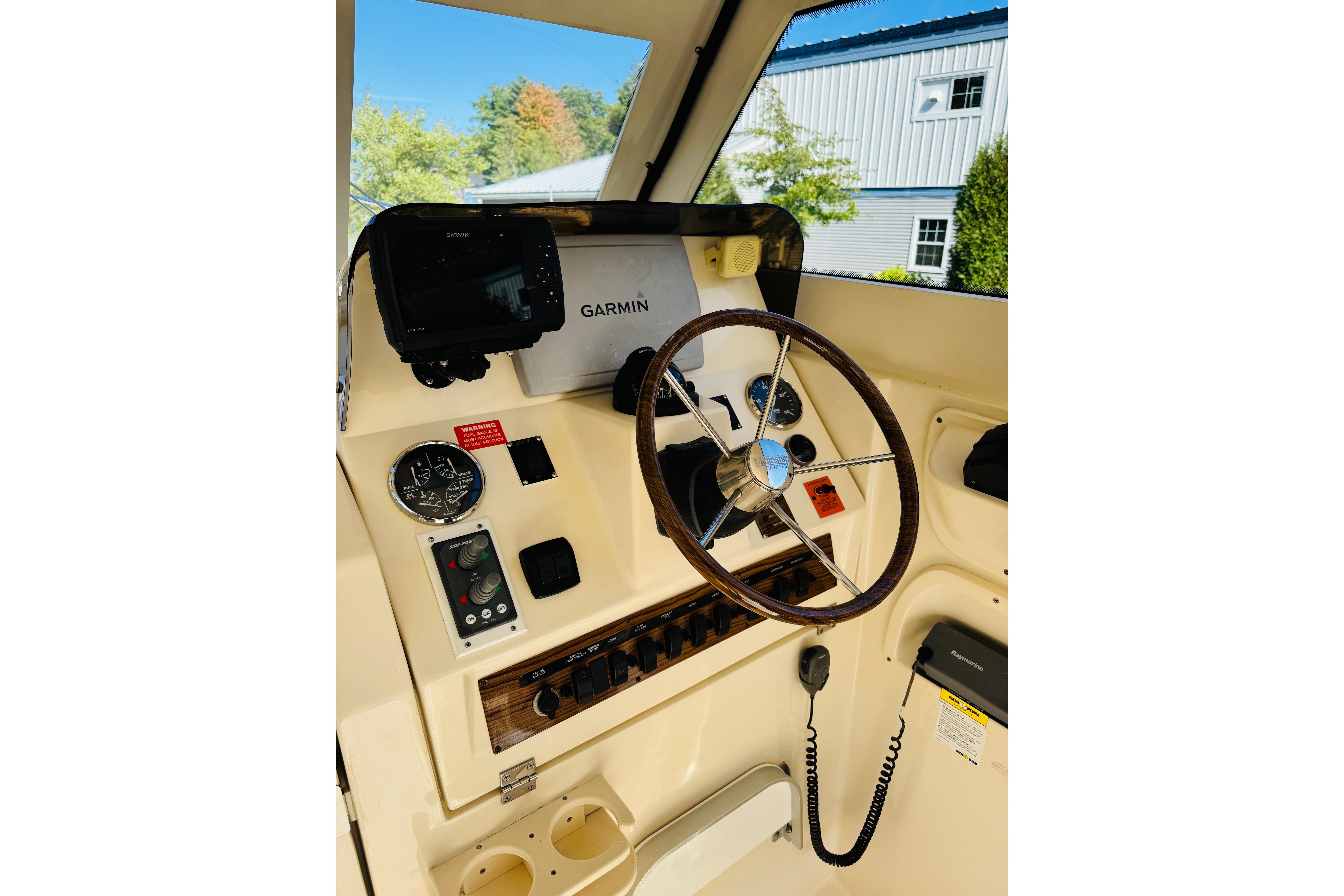 2006 Mainship Pilot 30 Sedan helm with Garmin navigation, steering wheel, and control panel.