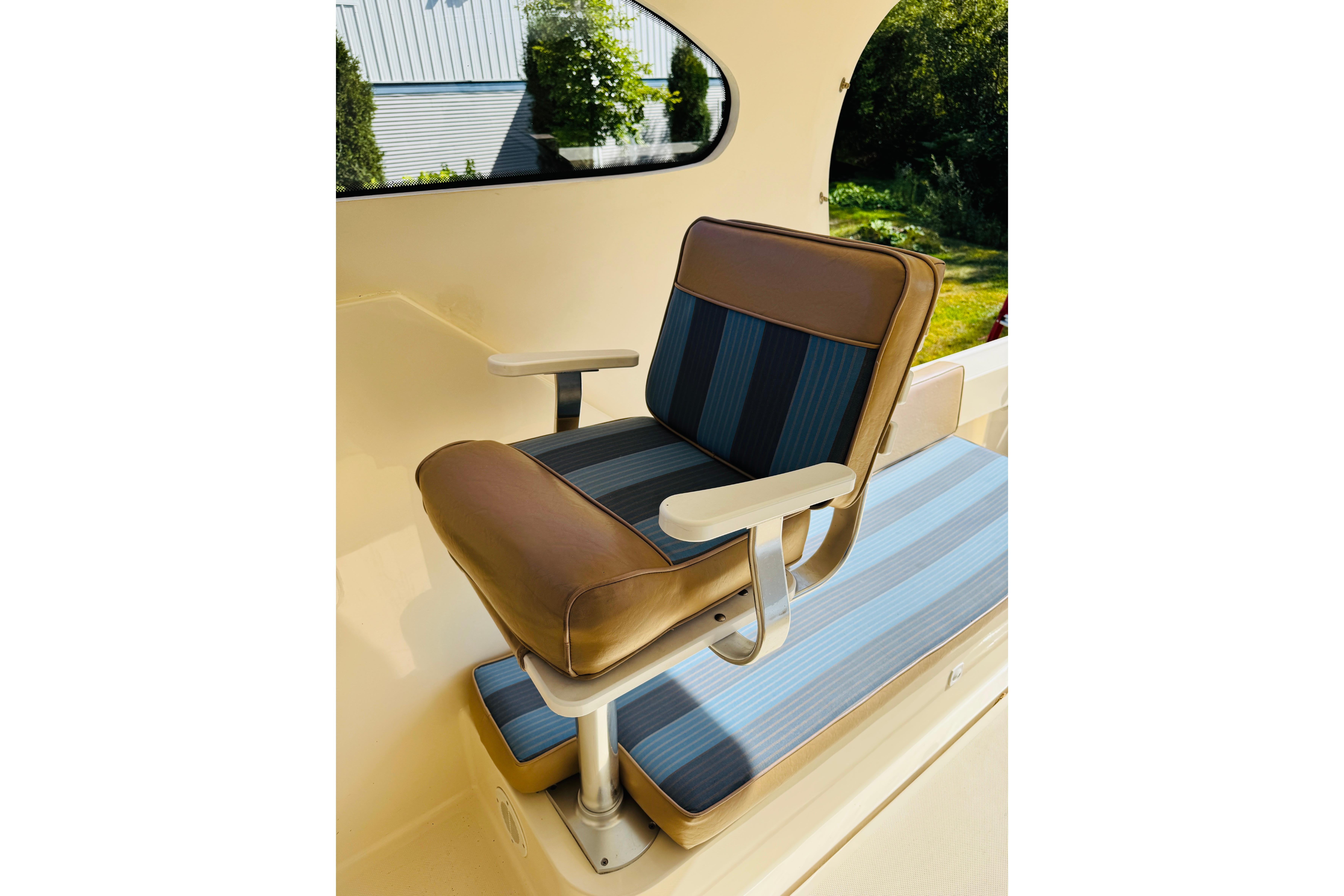 2006 Mainship Pilot 30 Sedan interior with cushioned seating and armrests.