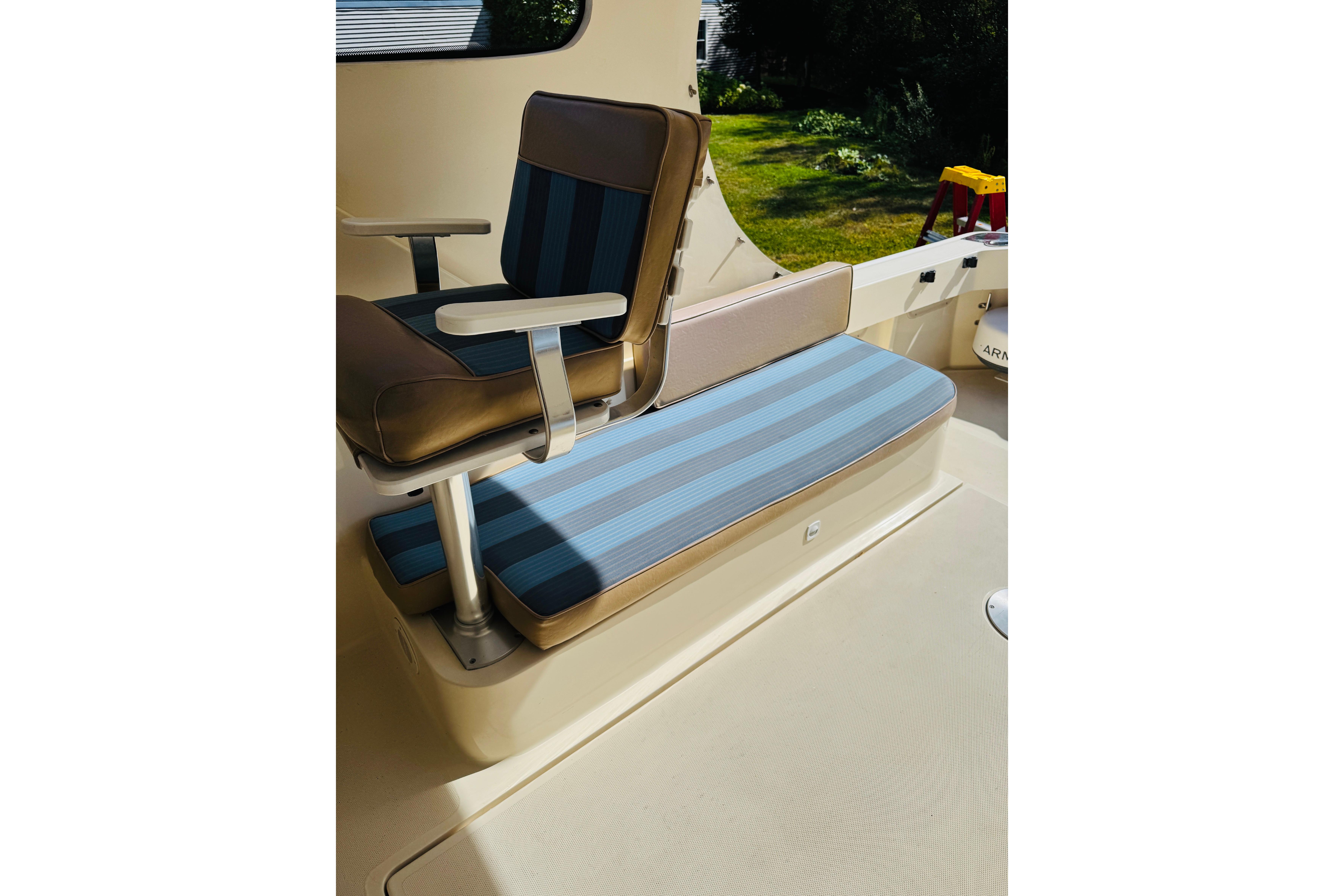 2006 Mainship Pilot 30 Sedan interior with striped seating and armchair.
