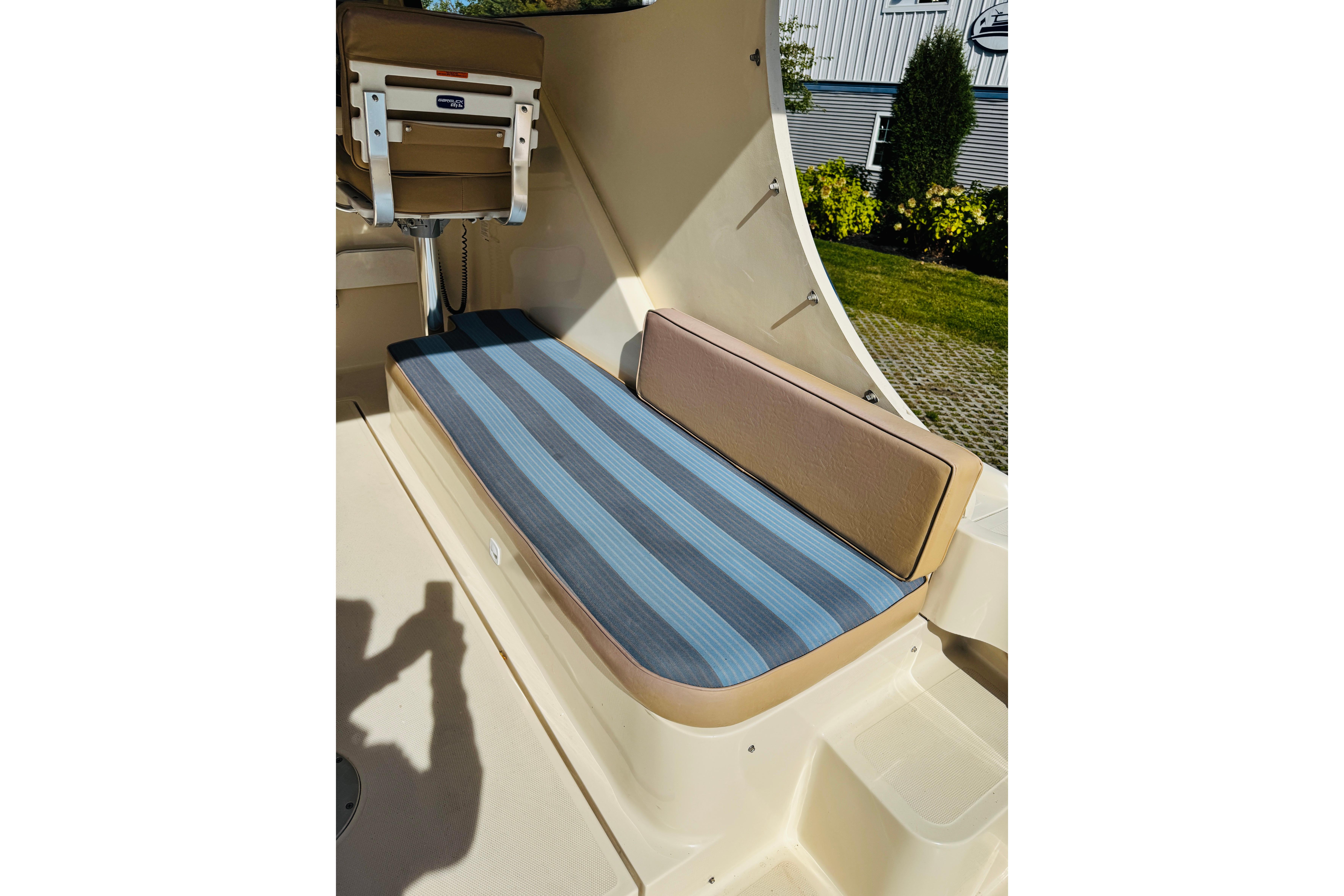 2006 Mainship Pilot 30 Sedan interior with striped seating and helm chair.