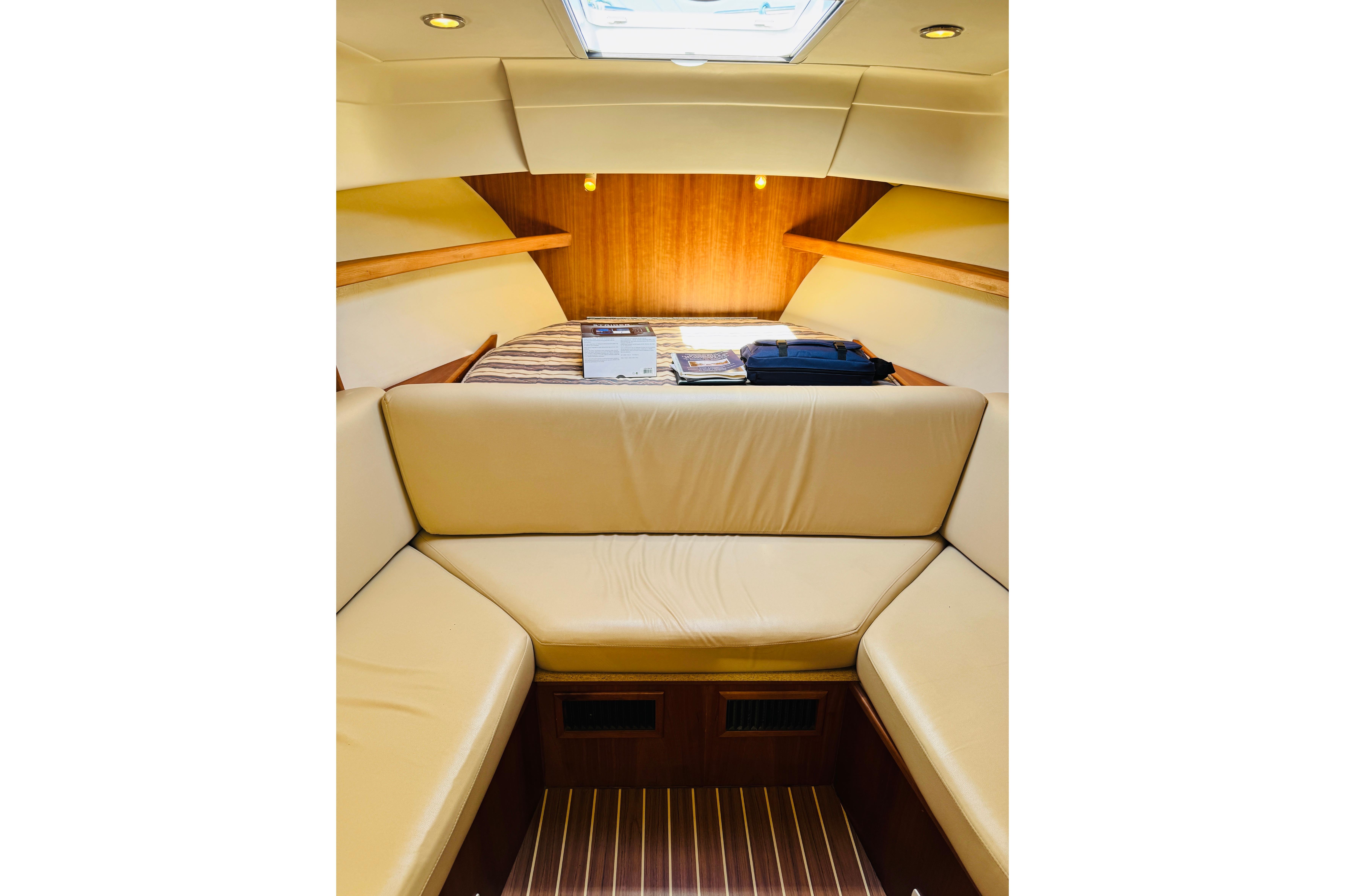 2006 Mainship Pilot 30 Sedan interior with beige seating and wood accents.