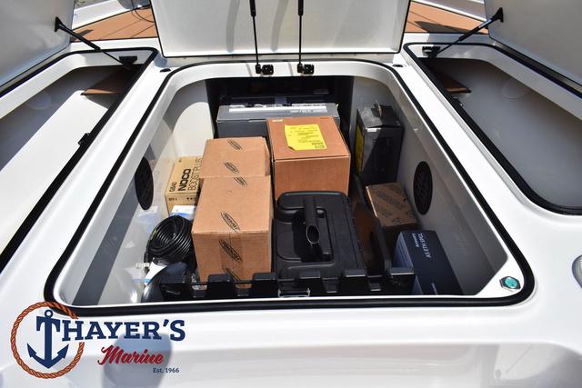 Open storage compartment of 2025 Ranger Z520R Cup-Equipped boat with various boxes and equipment.