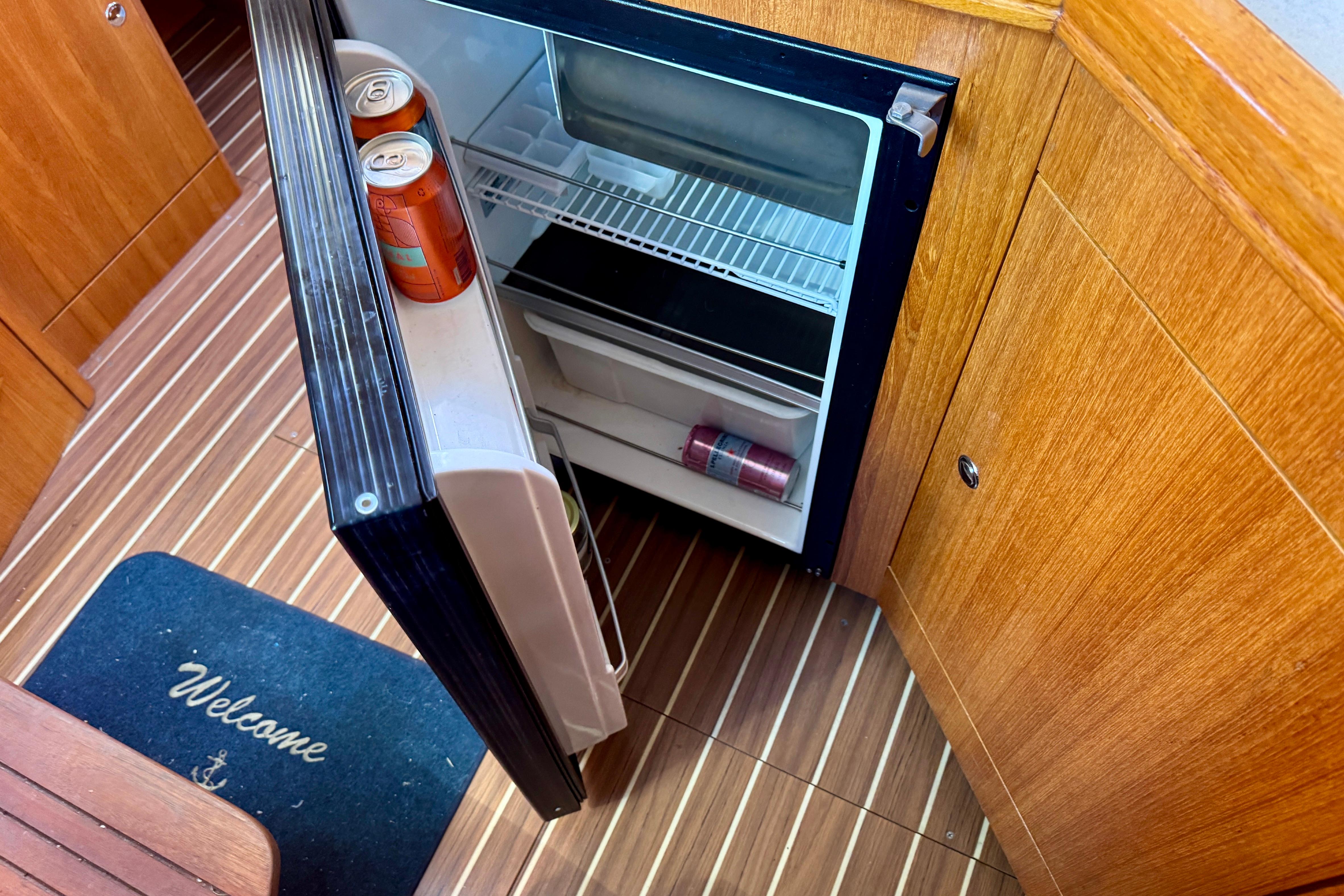 Open mini fridge on 2003 Hunter 36 yacht with drinks inside.