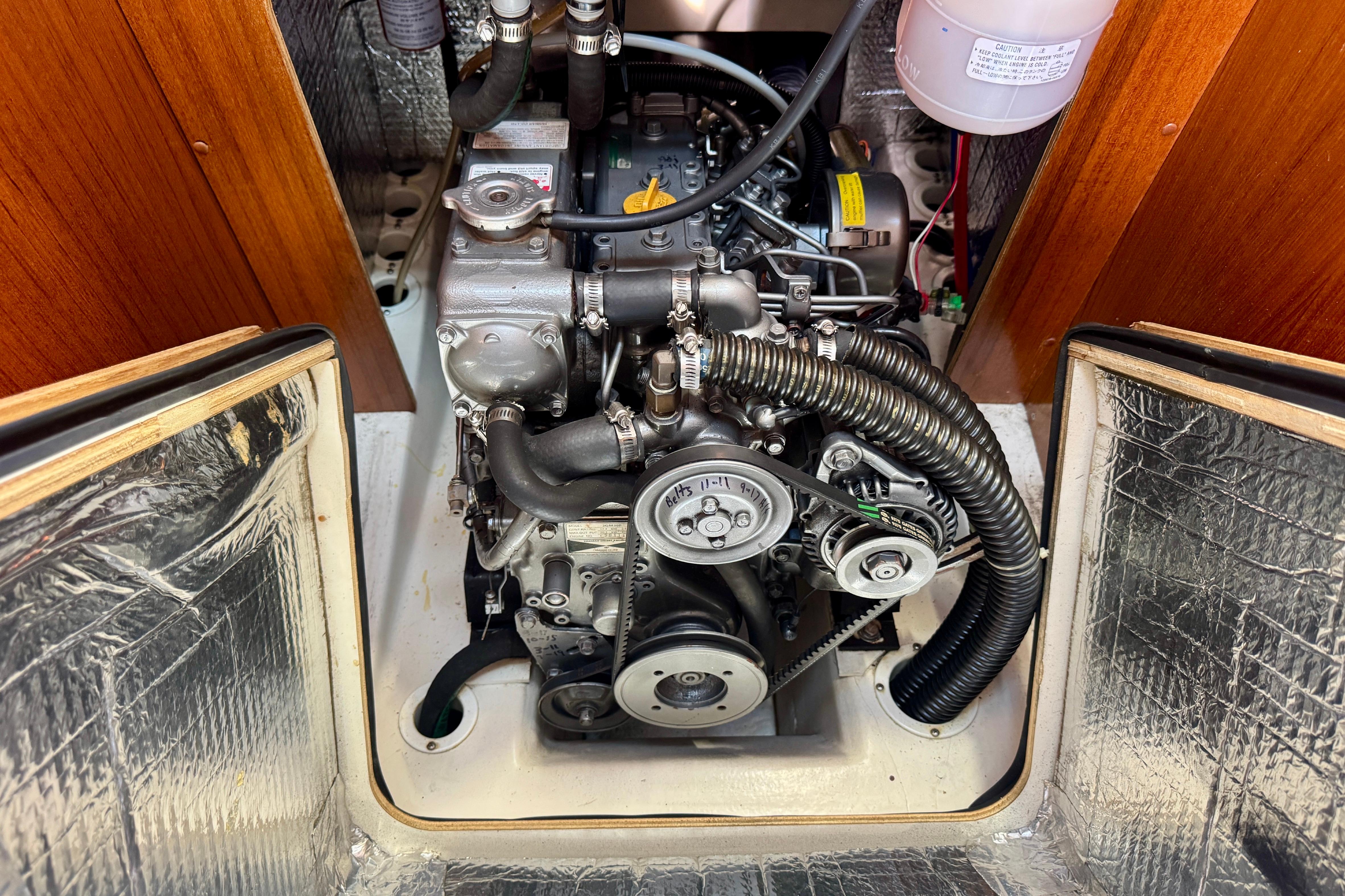 Engine compartment of a 2003 Hunter 36 sailboat, showcasing mechanical components and hoses.