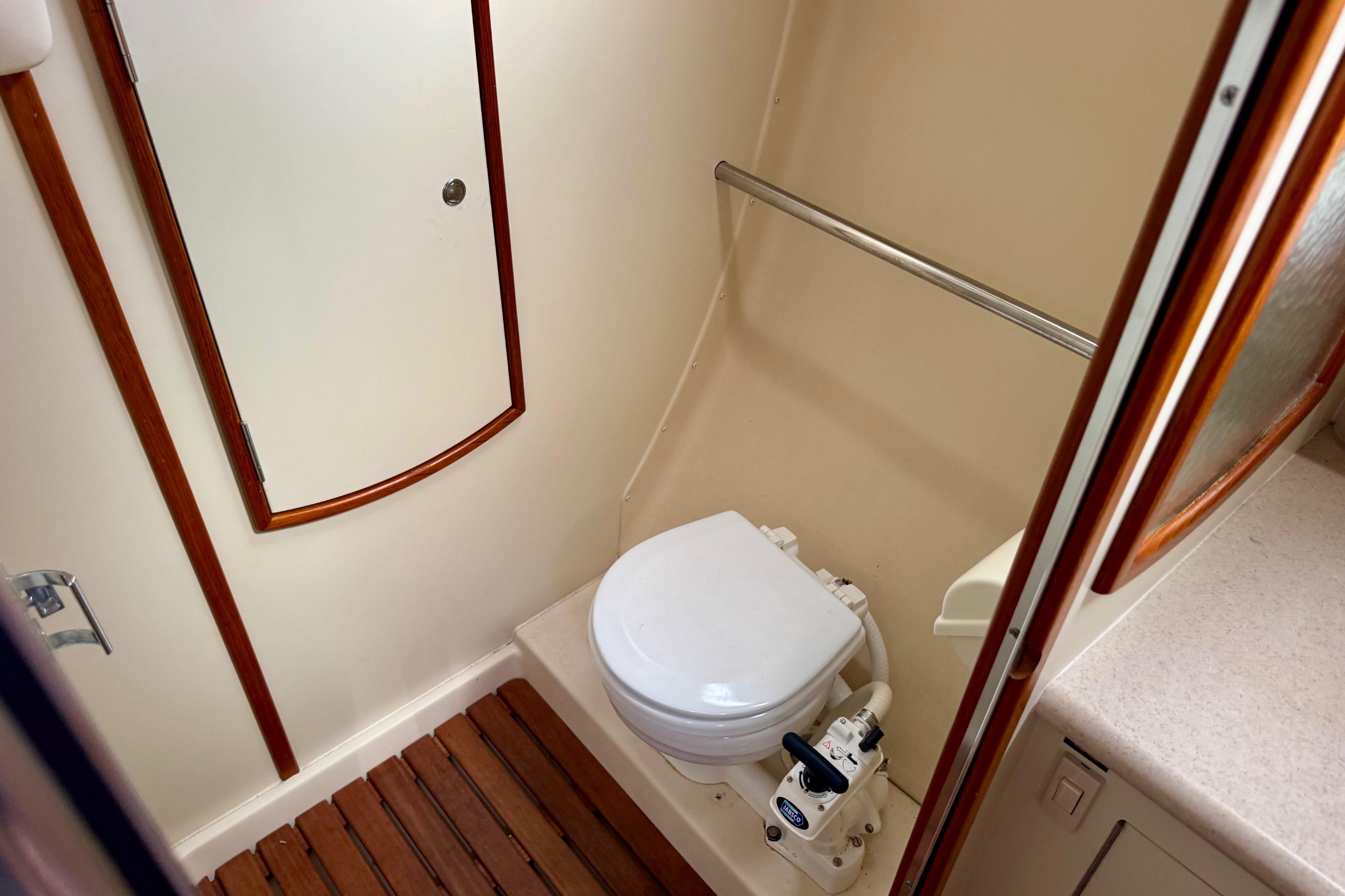 2003 Hunter 36 yacht bathroom with toilet, wooden floor, and storage cabinet.