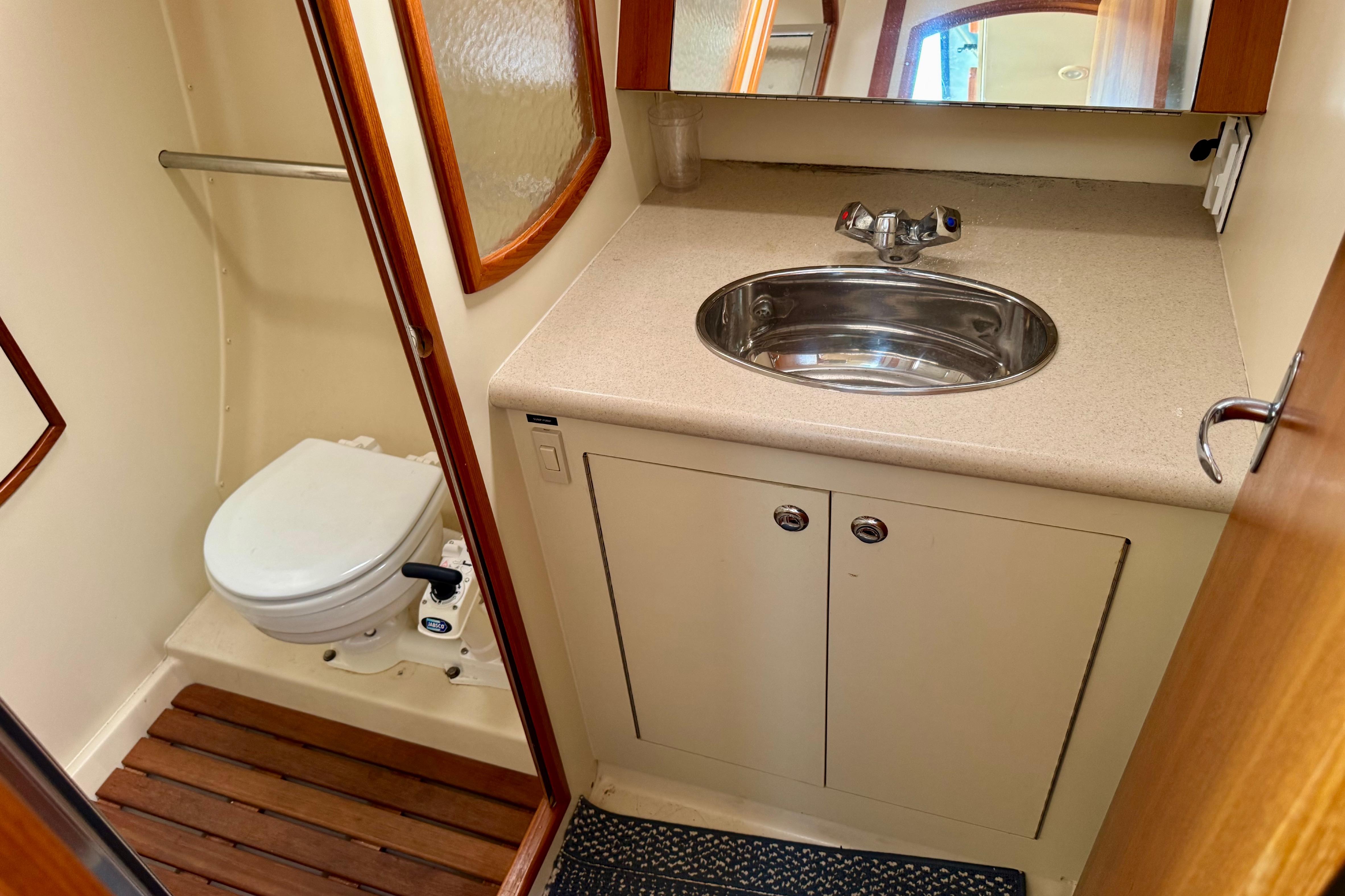 2003 Hunter 36 yacht bathroom with sink, toilet, and wooden floor accents.