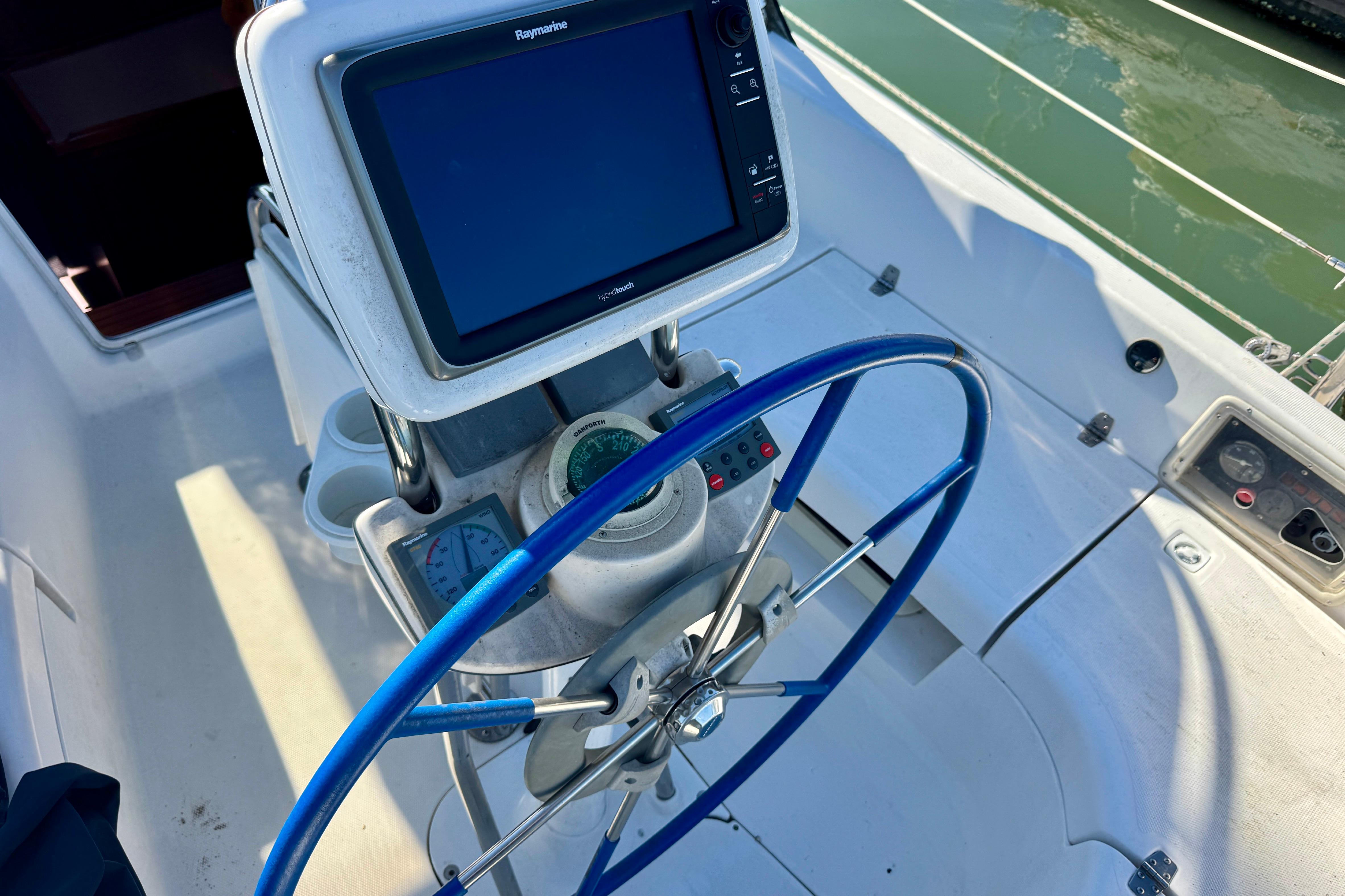 Steering wheel and navigation system on 2003 Hunter 36 sailboat cockpit.