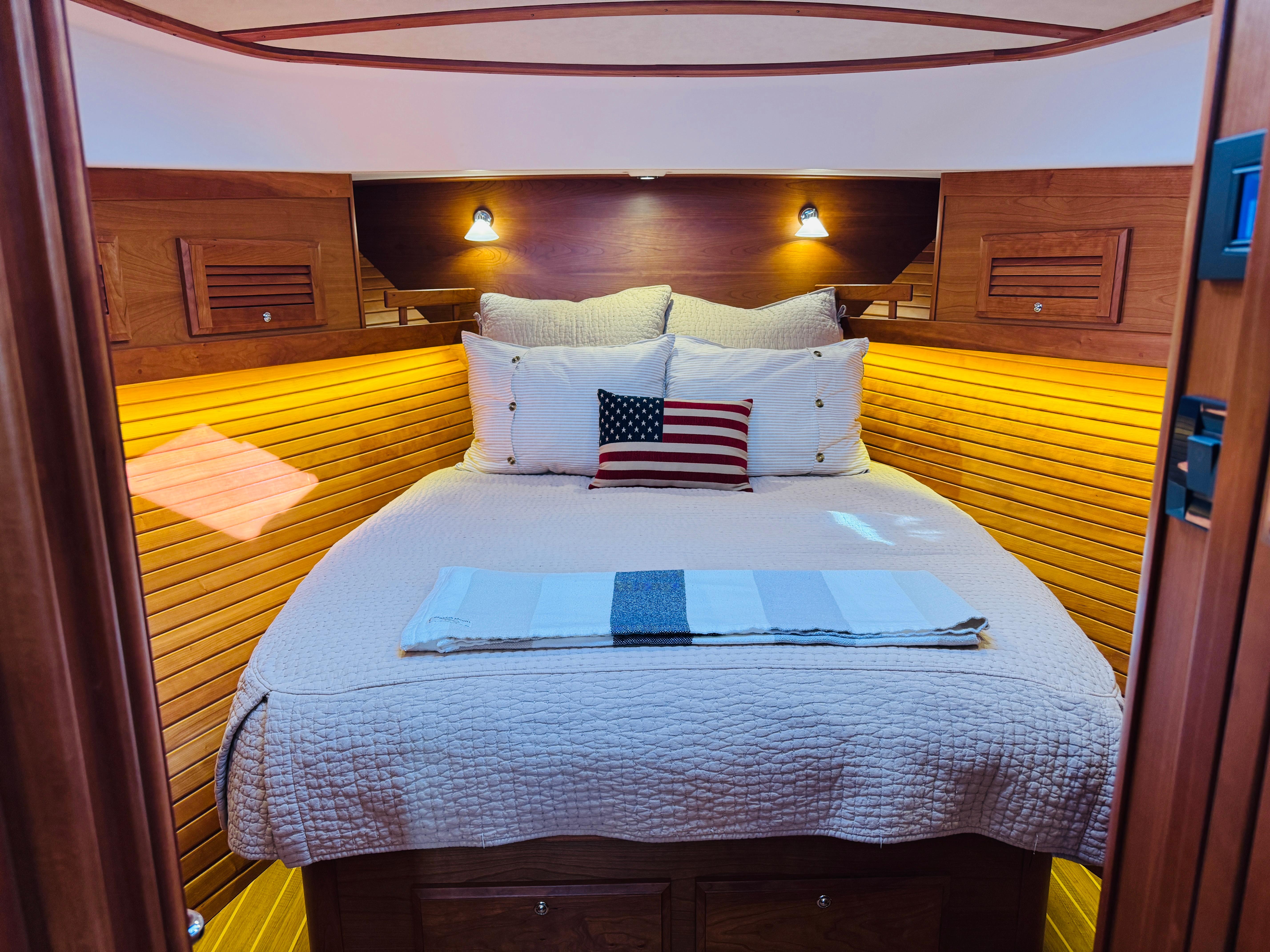 Cozy cabin interior of 2018 Sabre 42 Salon Express with wooden paneling and plush bedding.
