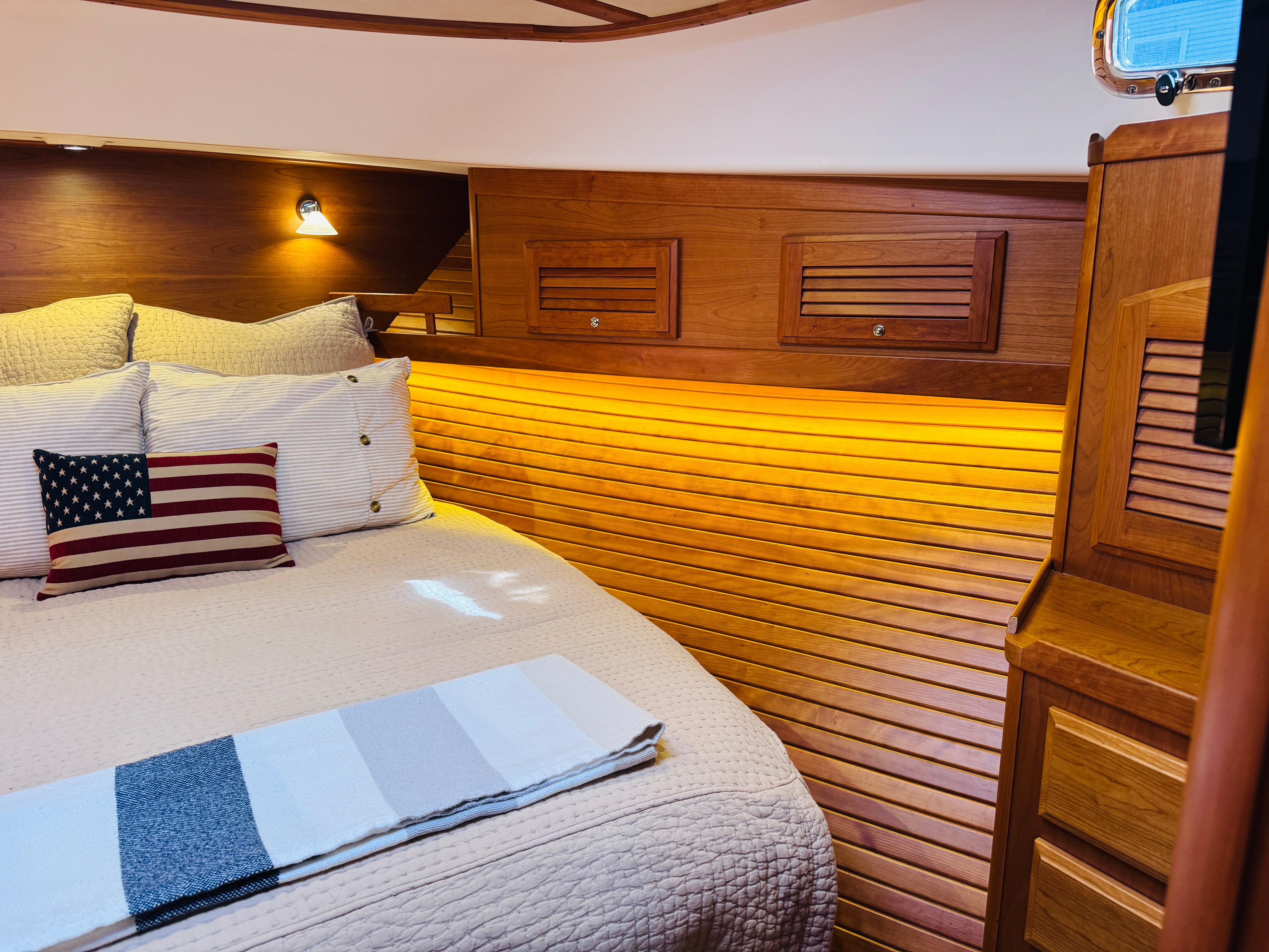 Luxurious cabin interior of 2018 Sabre 42 Salon Express with cozy bedding and warm lighting.