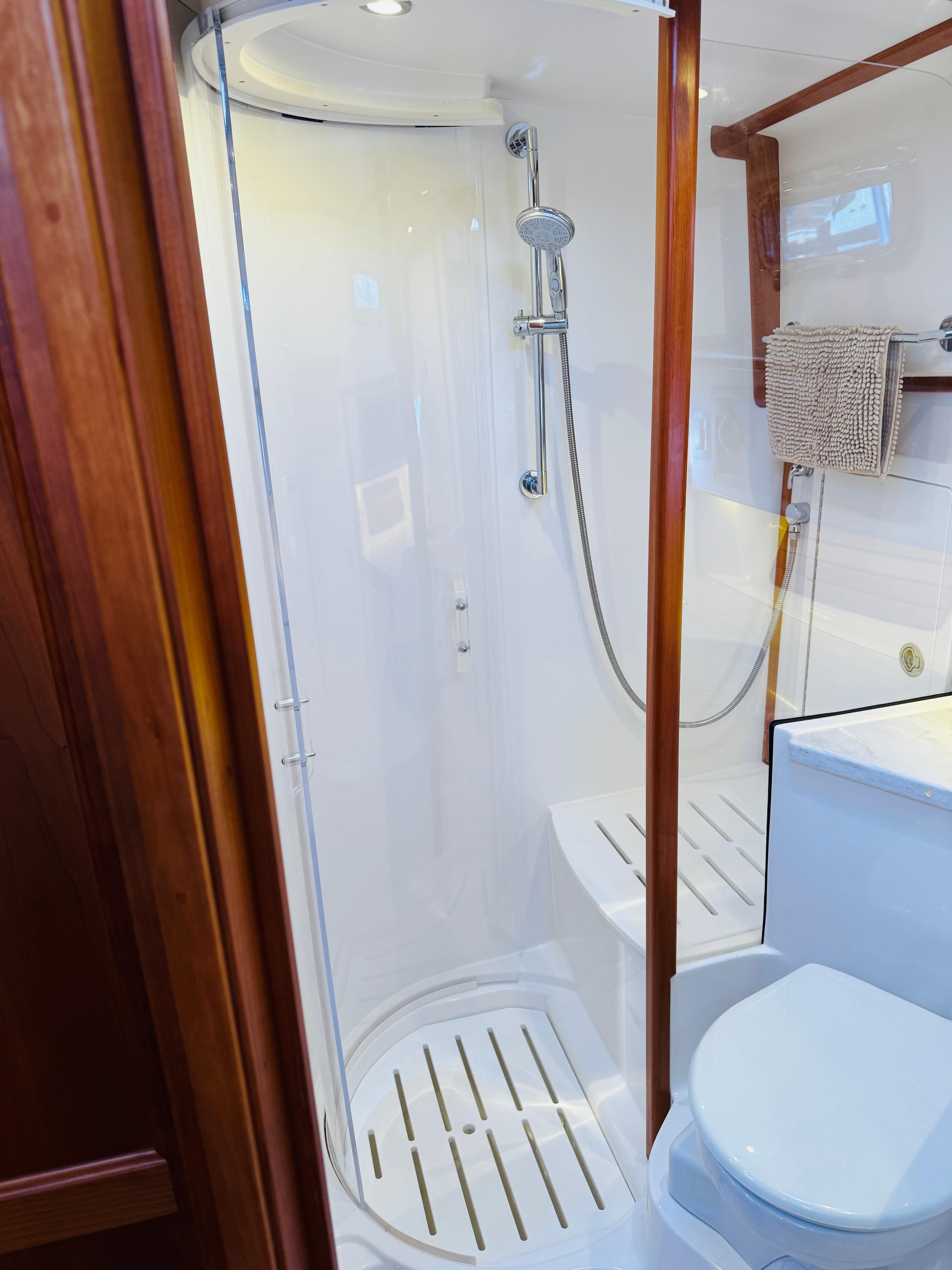 2018 Sabre 42 Salon Express bathroom with shower and toilet, featuring wooden accents.