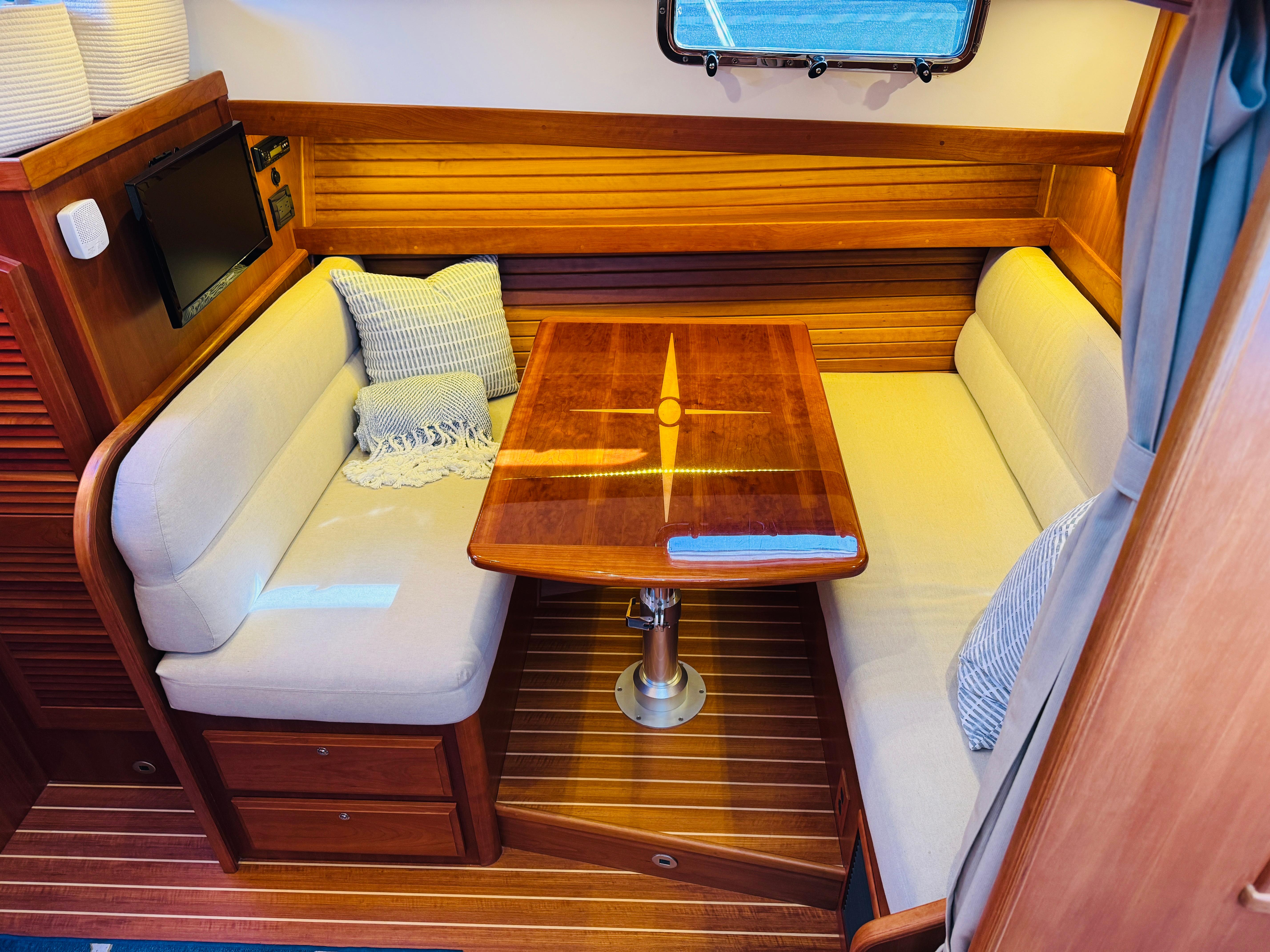 2018 Sabre 42 Salon Express interior with wooden table and cushioned seating.