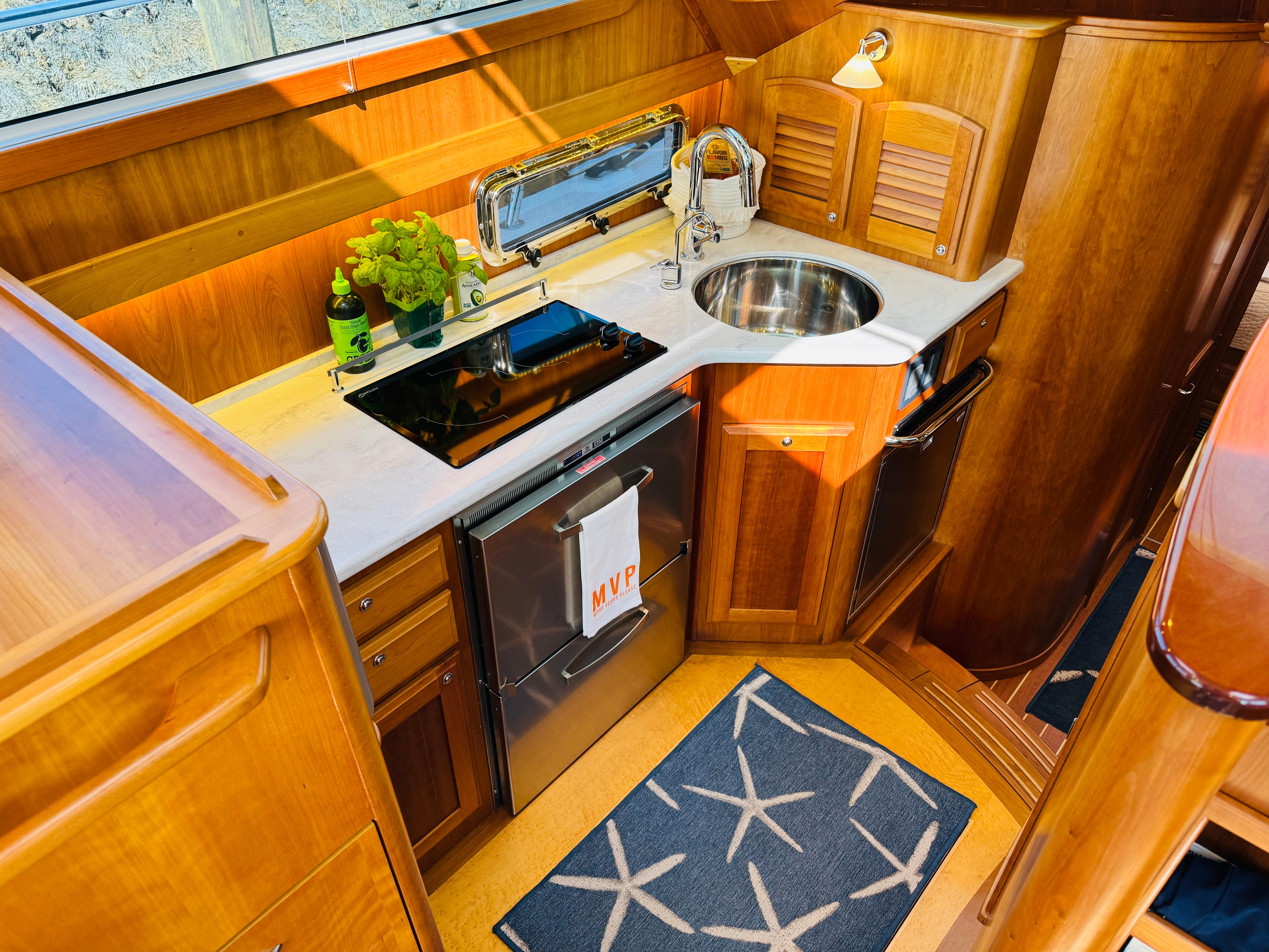 Luxurious galley in 2018 Sabre 42 Salon Express yacht with wood cabinetry and modern appliances.
