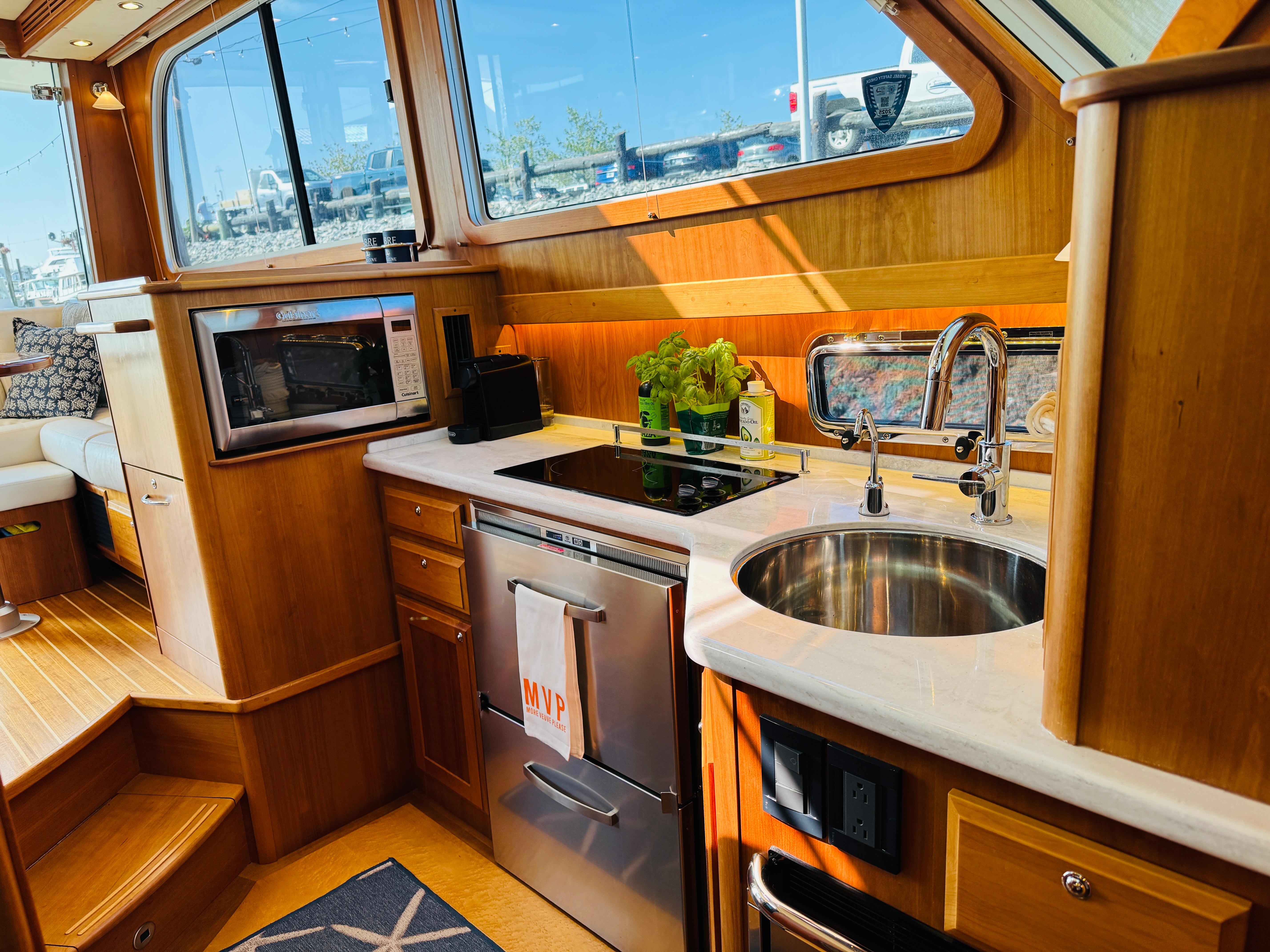Luxurious 2018 Sabre 42 Salon Express yacht kitchen with modern appliances and elegant wood finish.