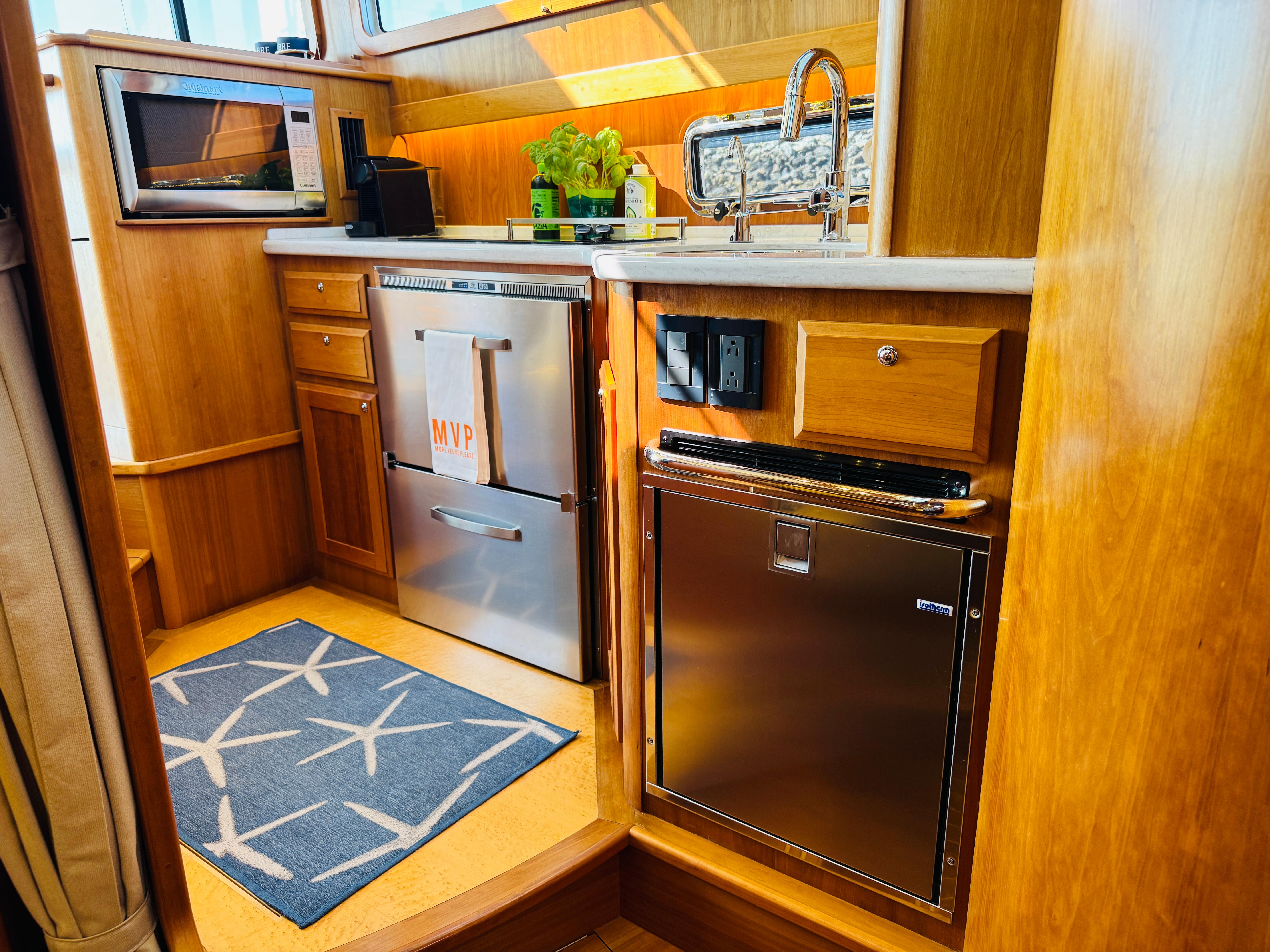 2018 Sabre 42 Salon Express kitchen with wood cabinetry, stainless appliances, and nautical decor.