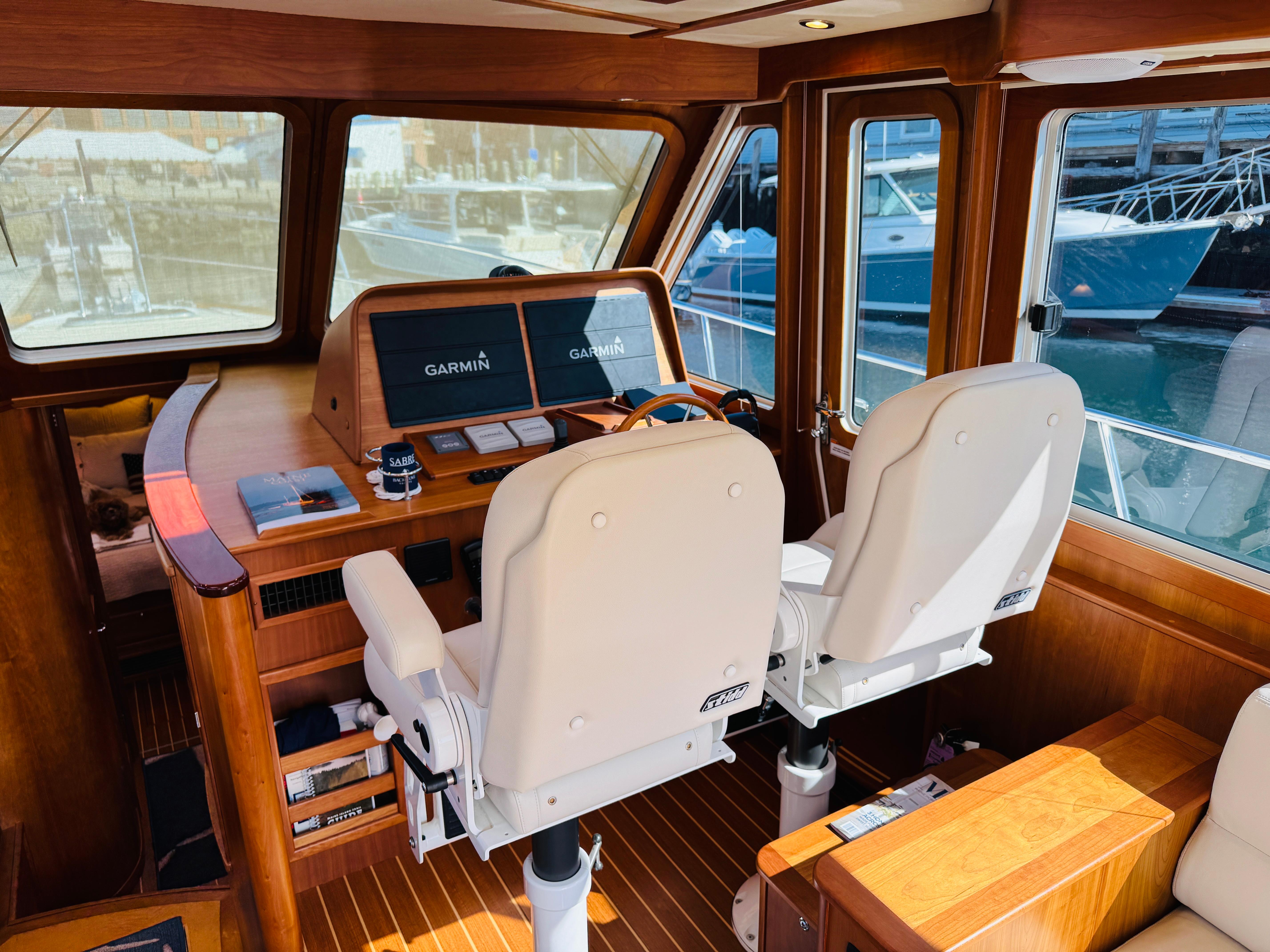 2018 Sabre 42 Salon Express helm with Garmin navigation, featuring luxurious wood interior and dual captain chairs.