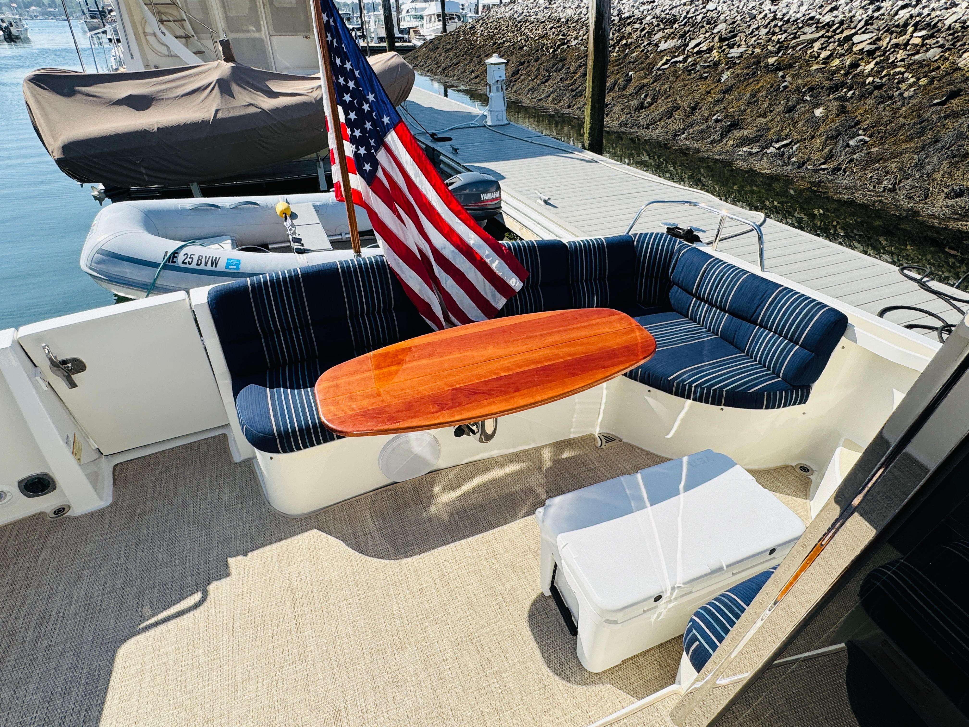2018 Sabre 42 Salon Express yacht with striped seating and wooden table on deck.