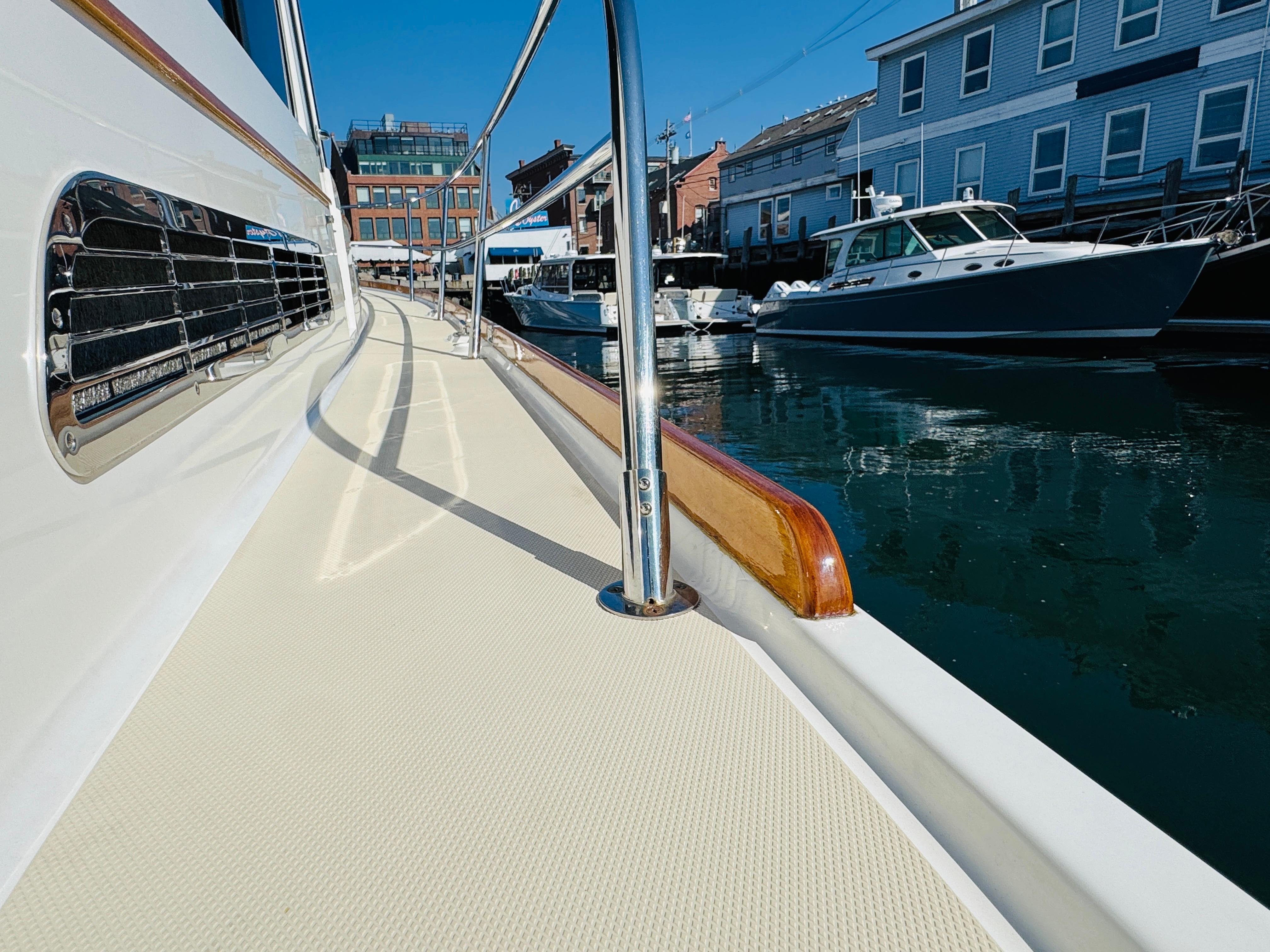 2018 Sabre 42 Salon Express yacht docked in a marina, showcasing sleek design and waterfront buildings.