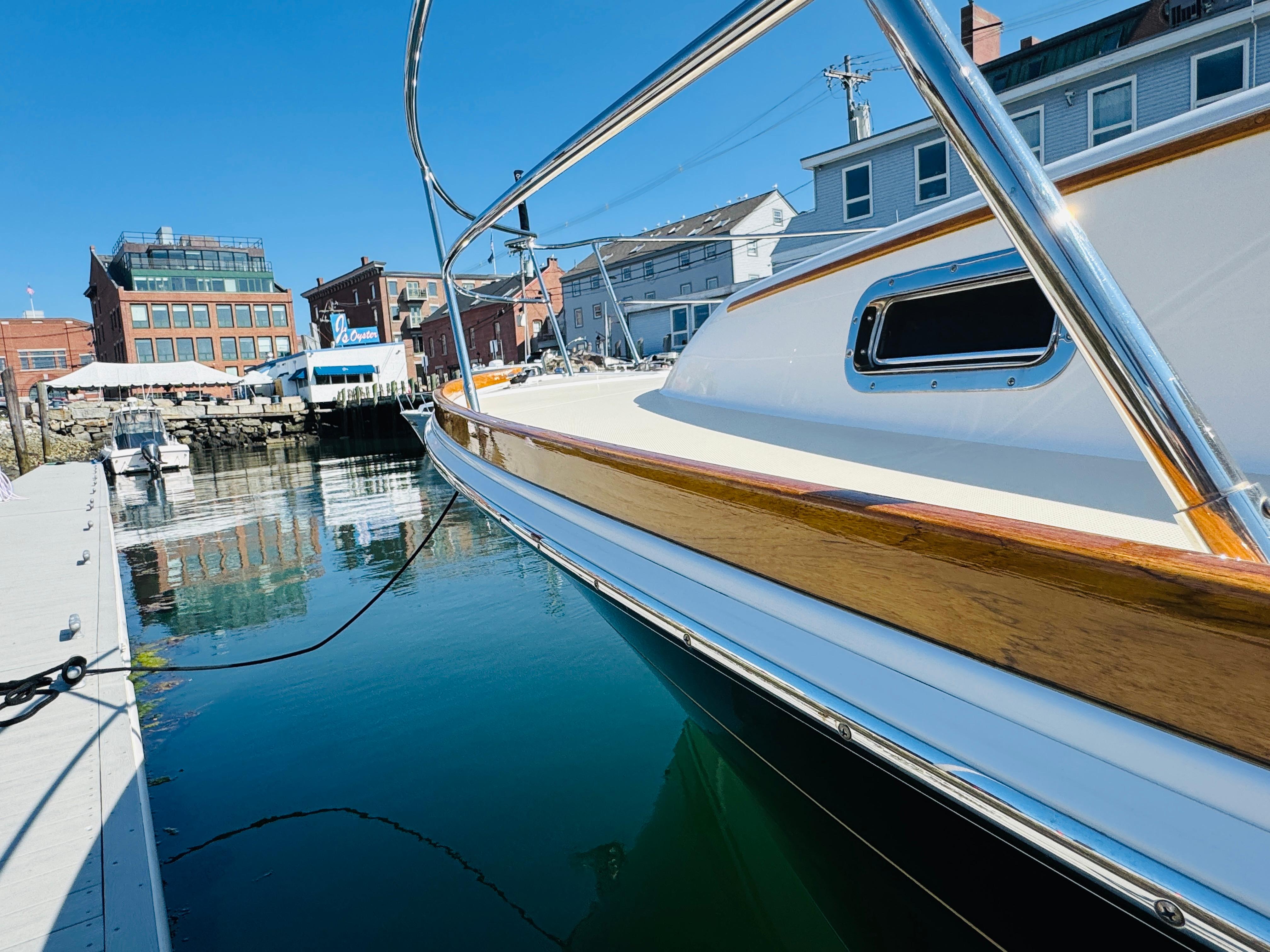 2018 Sabre 42 Salon Express yacht docked in a marina, reflecting on calm water.