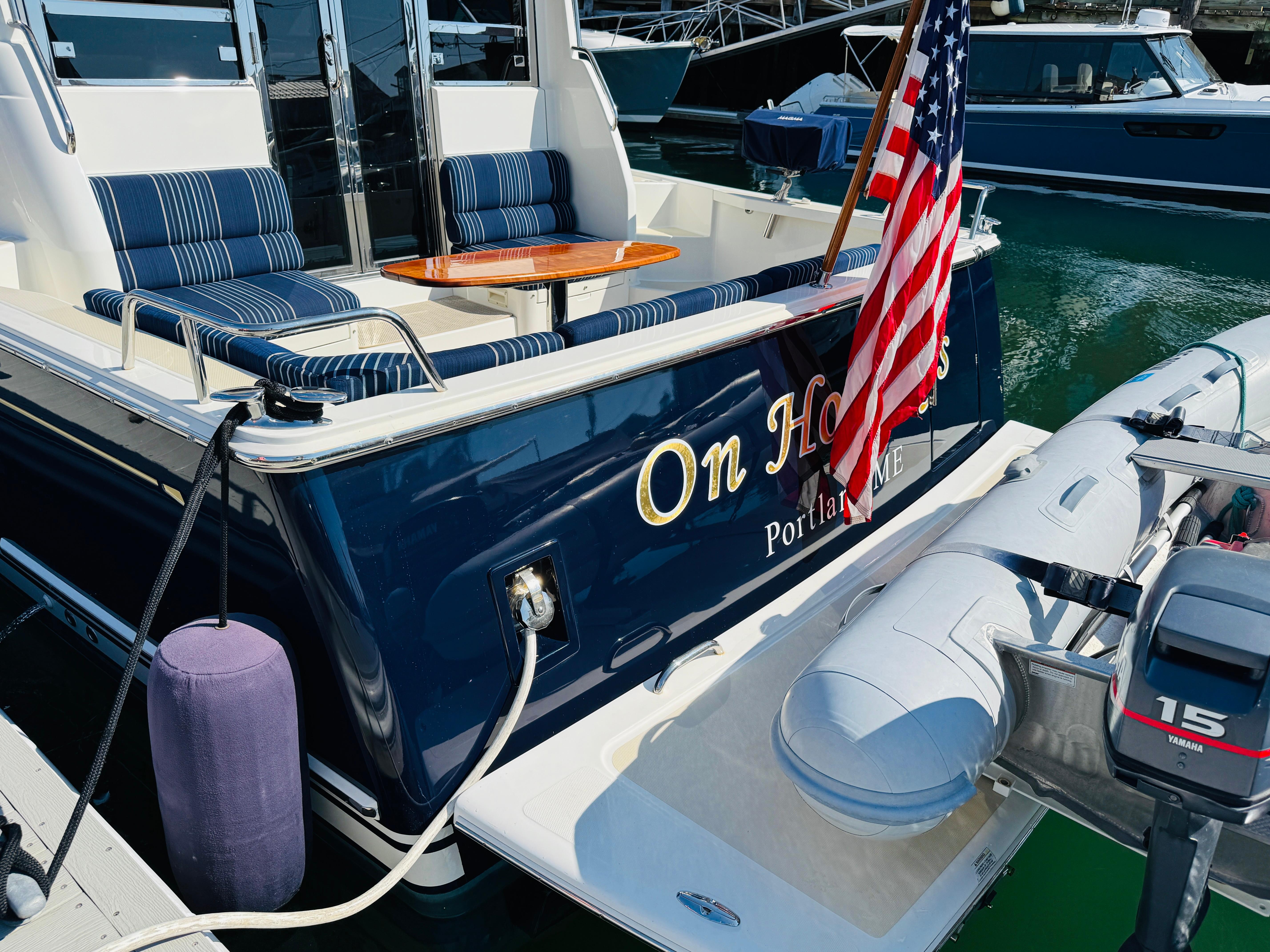 2018 Sabre 42 Salon Express yacht with American flag, docked in marina.