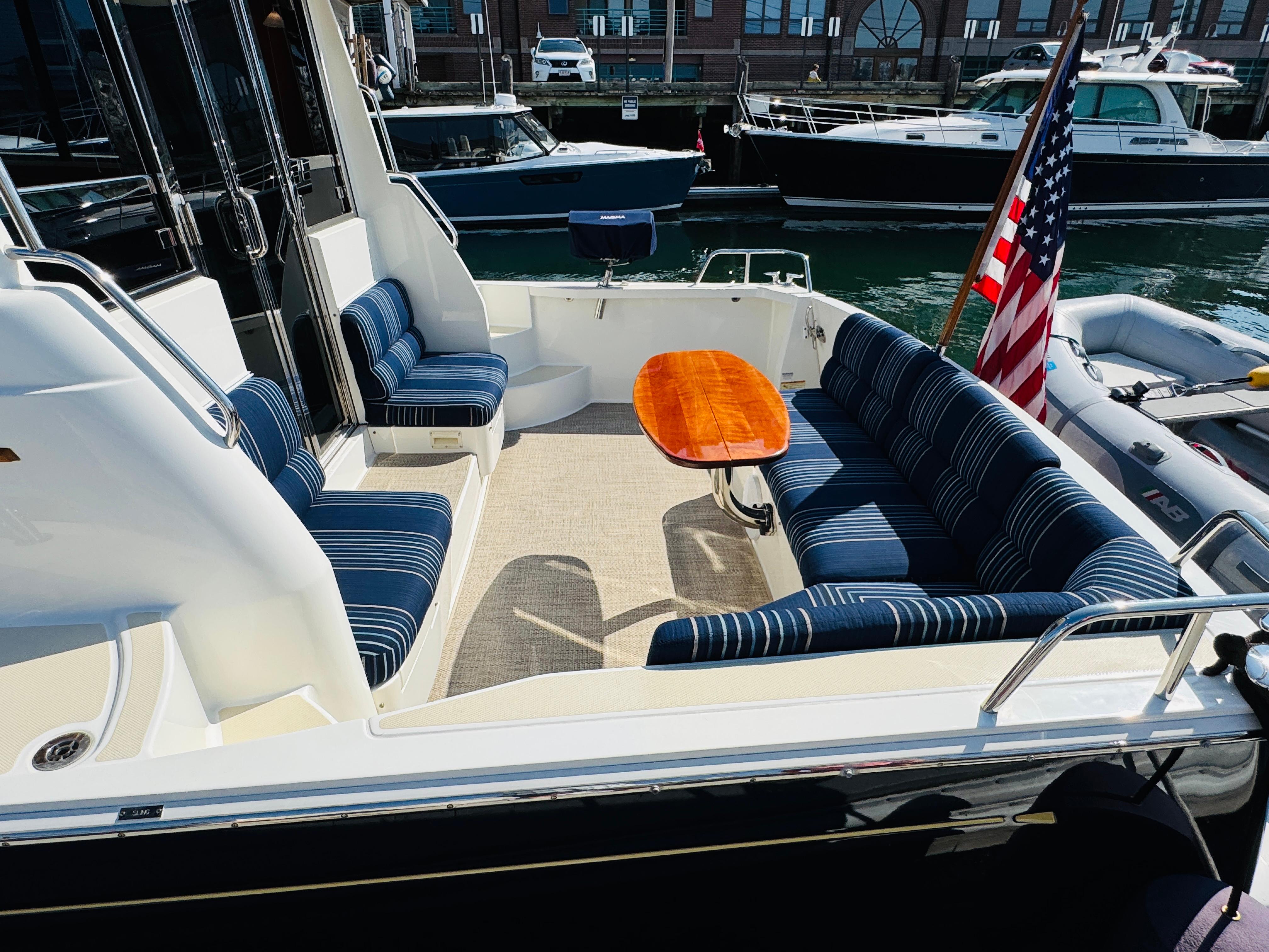 2018 Sabre 42 Salon Express yacht with striped seating and wooden table in the cockpit area.