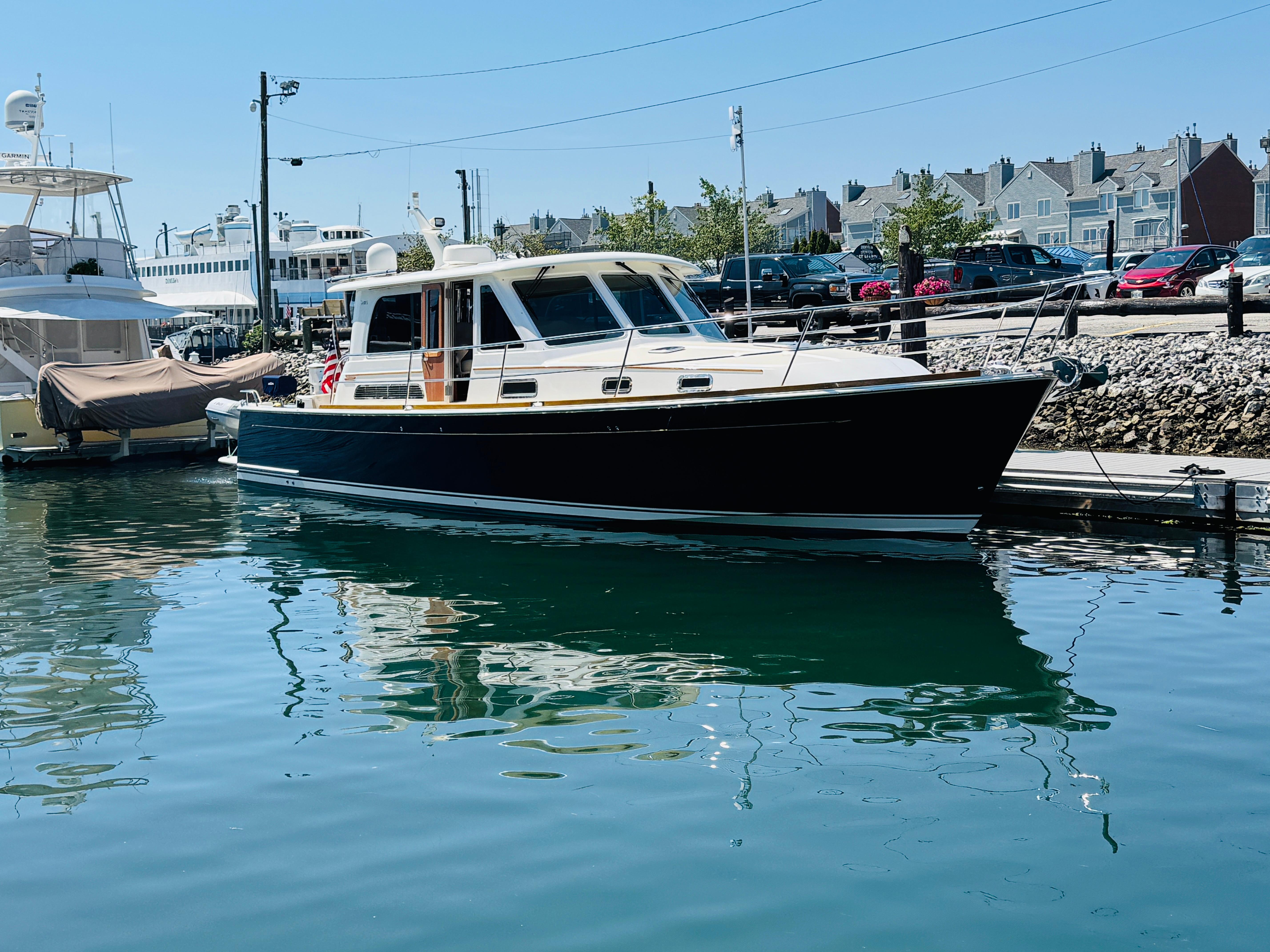 2018 Sabre 42 Salon Express yacht docked in a marina, reflecting on calm water.