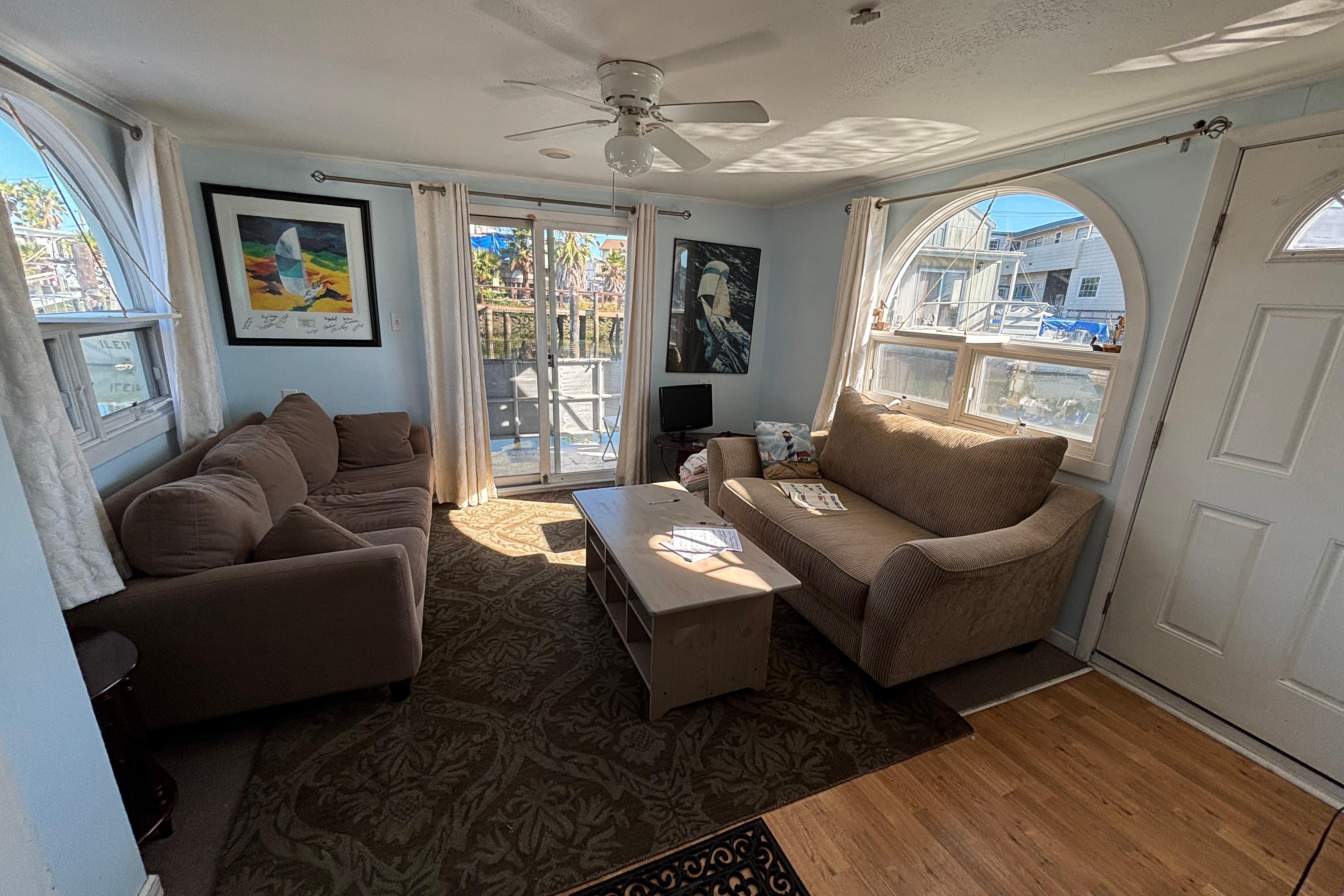 Cozy living room in 2004 River Floating Home with sofas, artwork, and natural light.