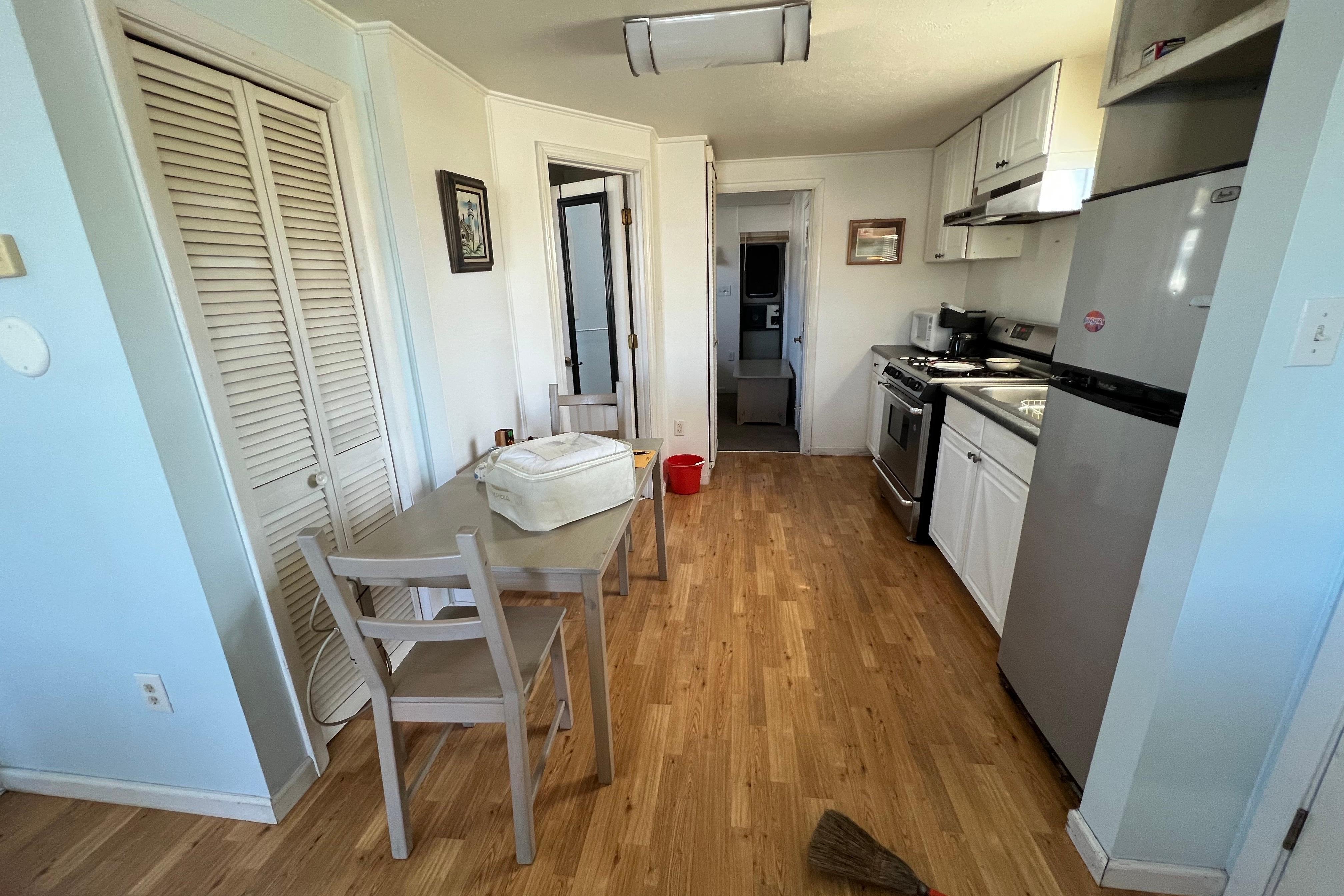 Compact kitchen and dining area in a 2004 River Floating Home with wooden flooring.