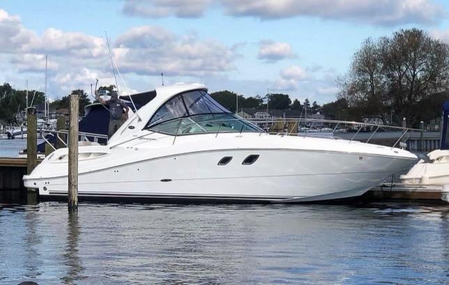 2008 Sea Ray 330 Sundancer yacht docked in a marina under a partly cloudy sky.