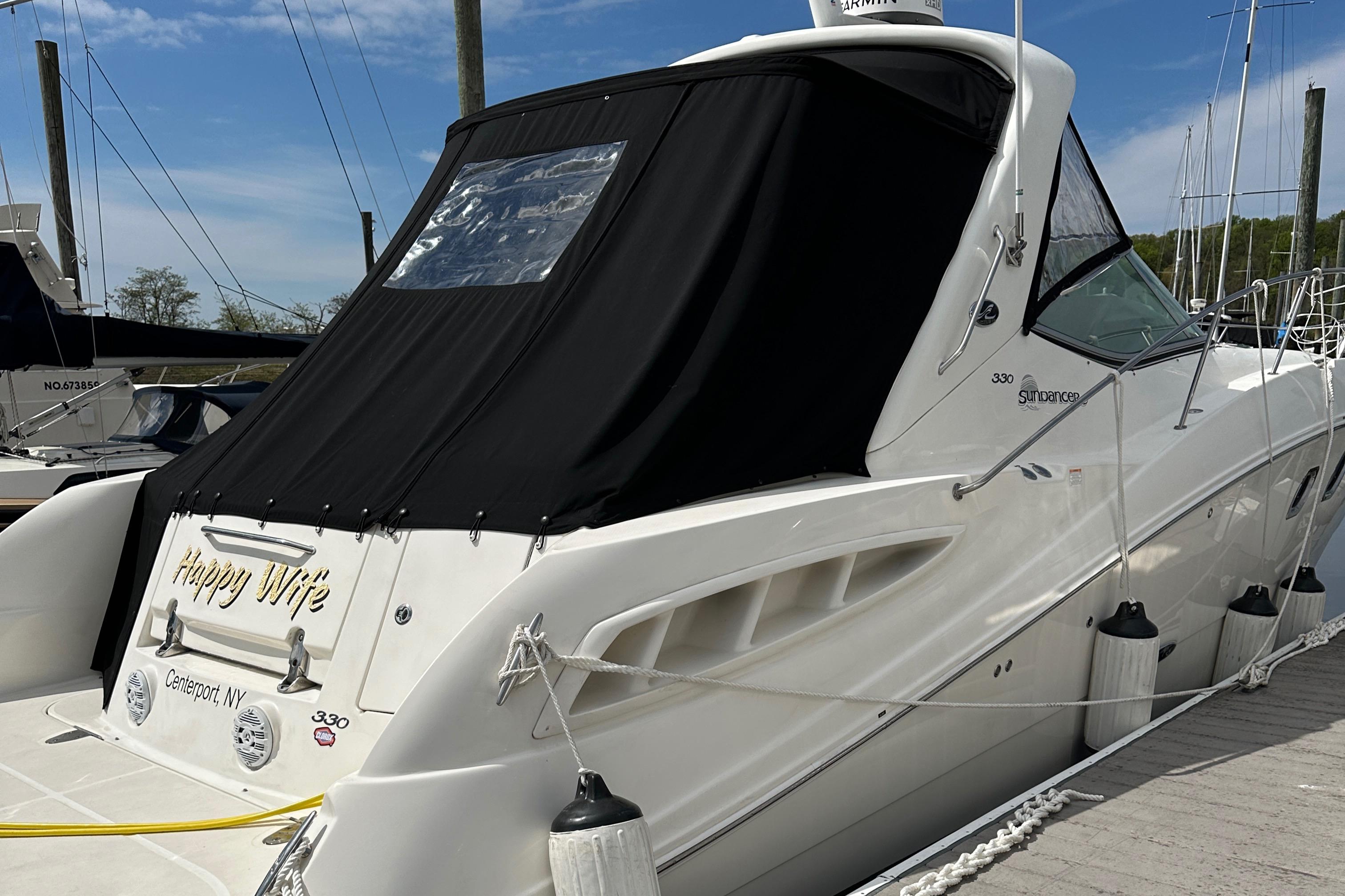 2008 Sea Ray 330 Sundancer docked, featuring sleek design and black canopy.