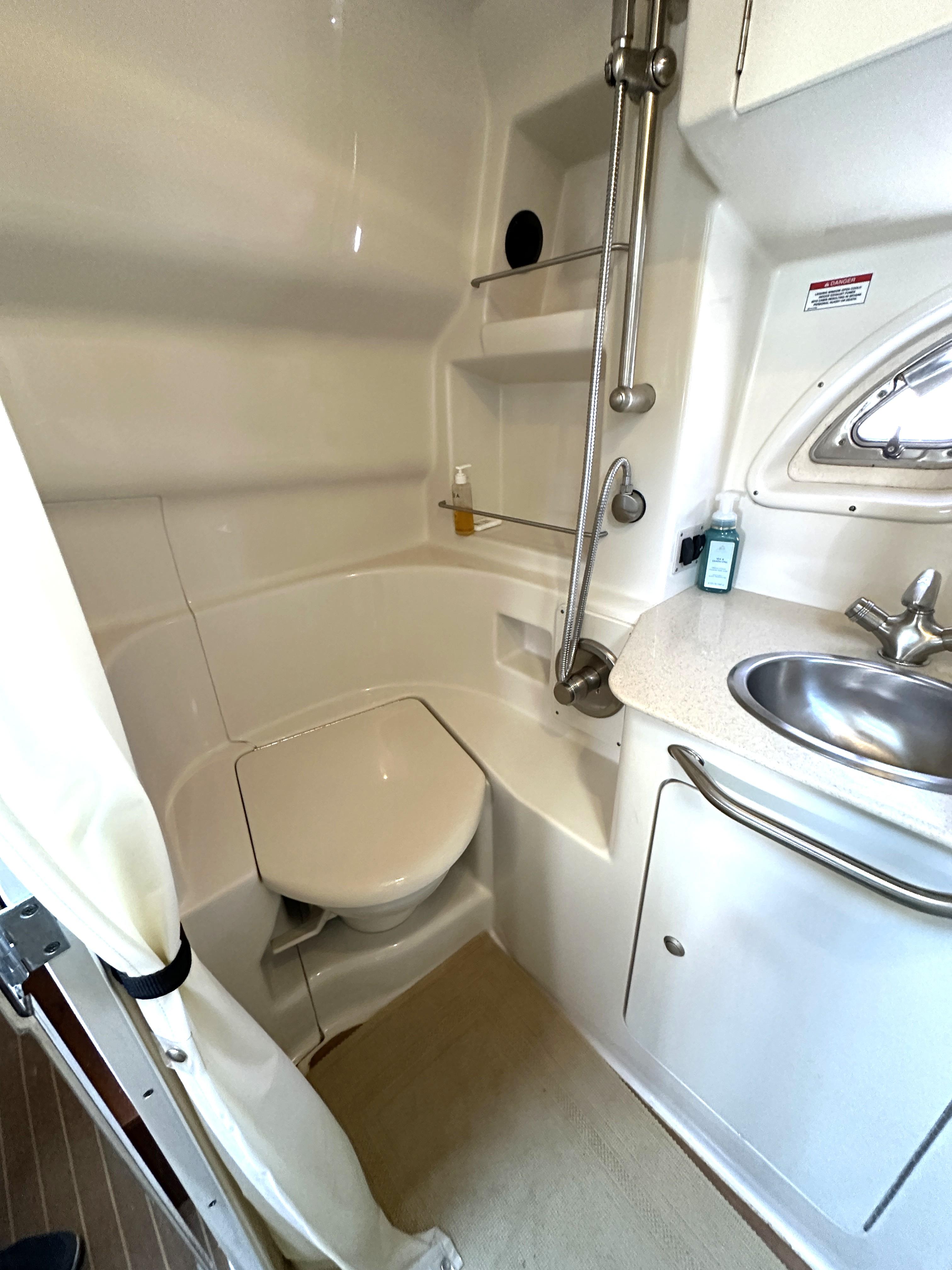2008 Sea Ray 330 Sundancer bathroom with shower, sink, and toilet.