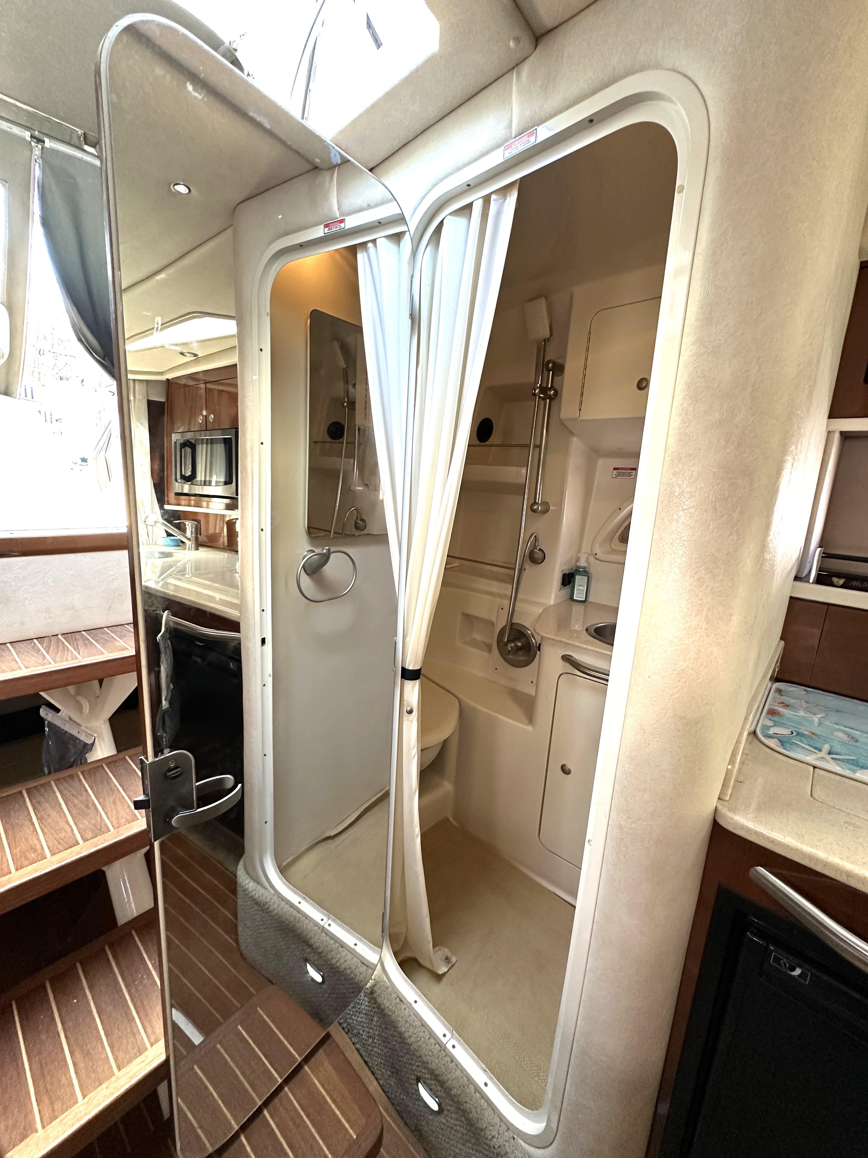 2008 Sea Ray 330 Sundancer interior with shower, wooden steps, and kitchenette.