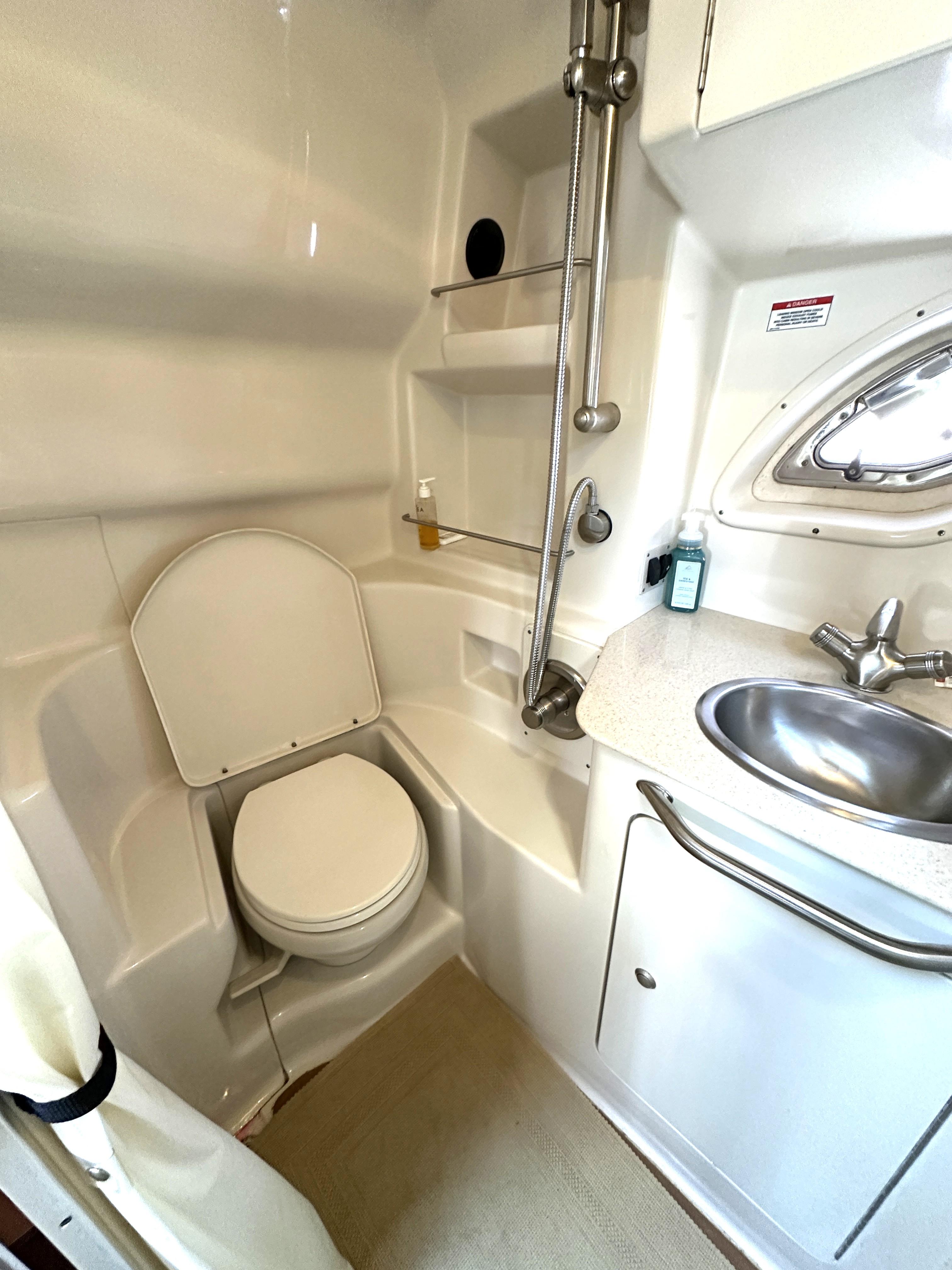 2008 Sea Ray 330 Sundancer bathroom with toilet, sink, and shower.