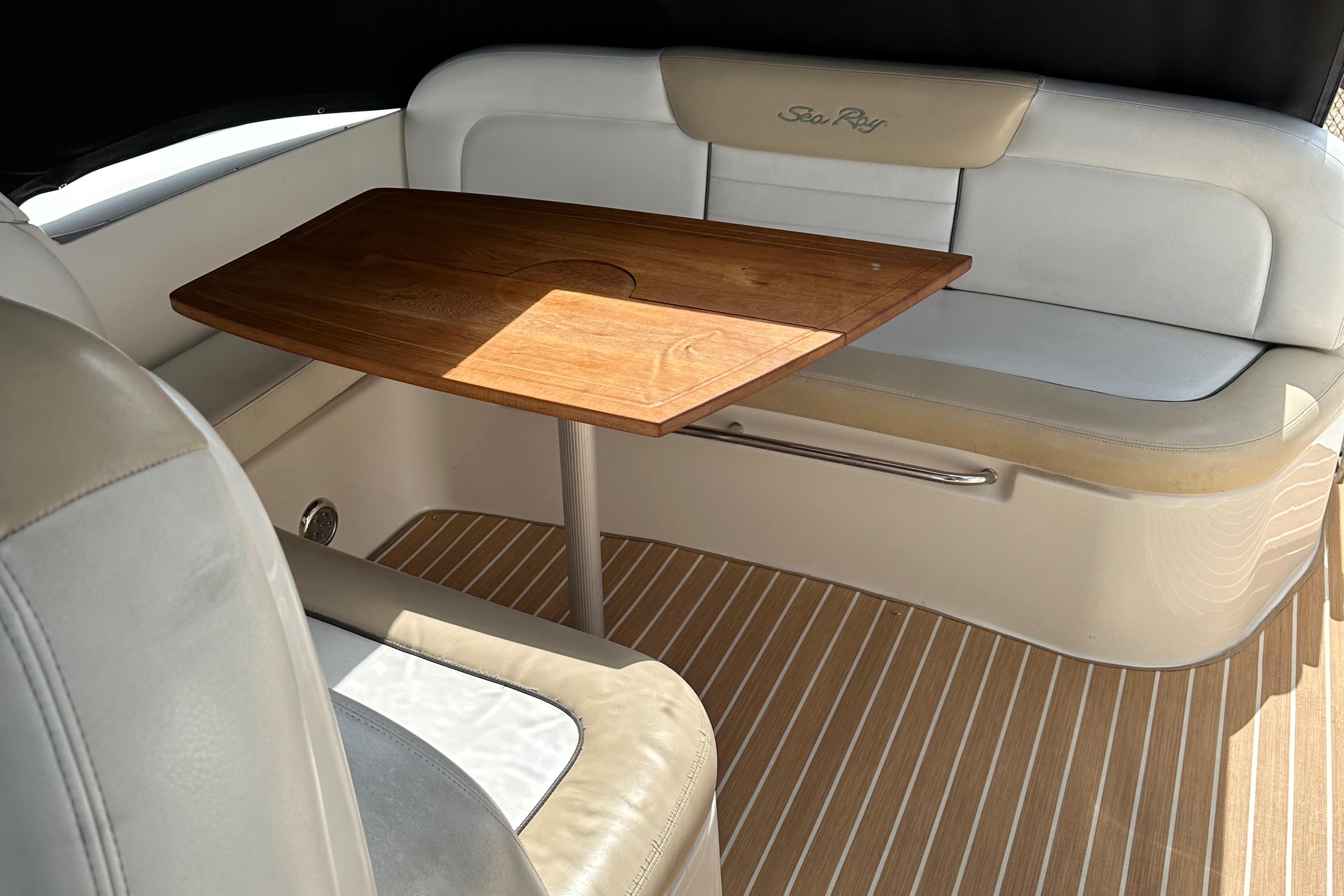 2008 Sea Ray 330 Sundancer interior with wooden table and cushioned seating.
