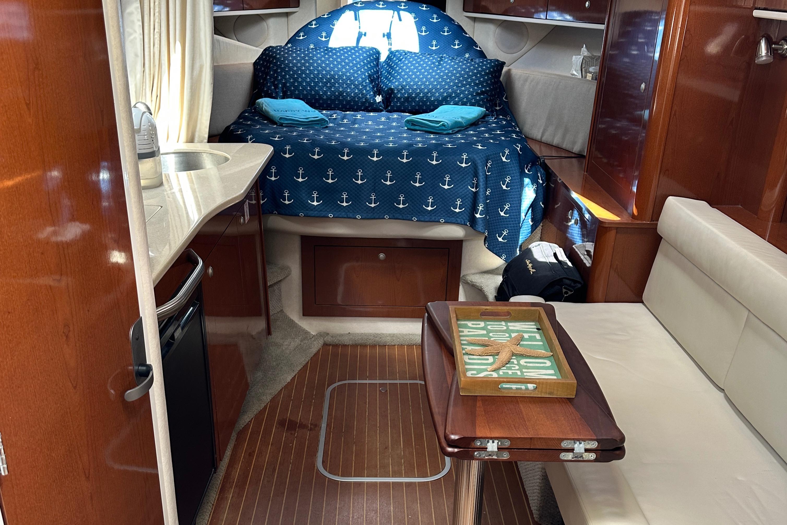2008 Sea Ray 330 Sundancer cabin with bed, kitchenette, and seating area.