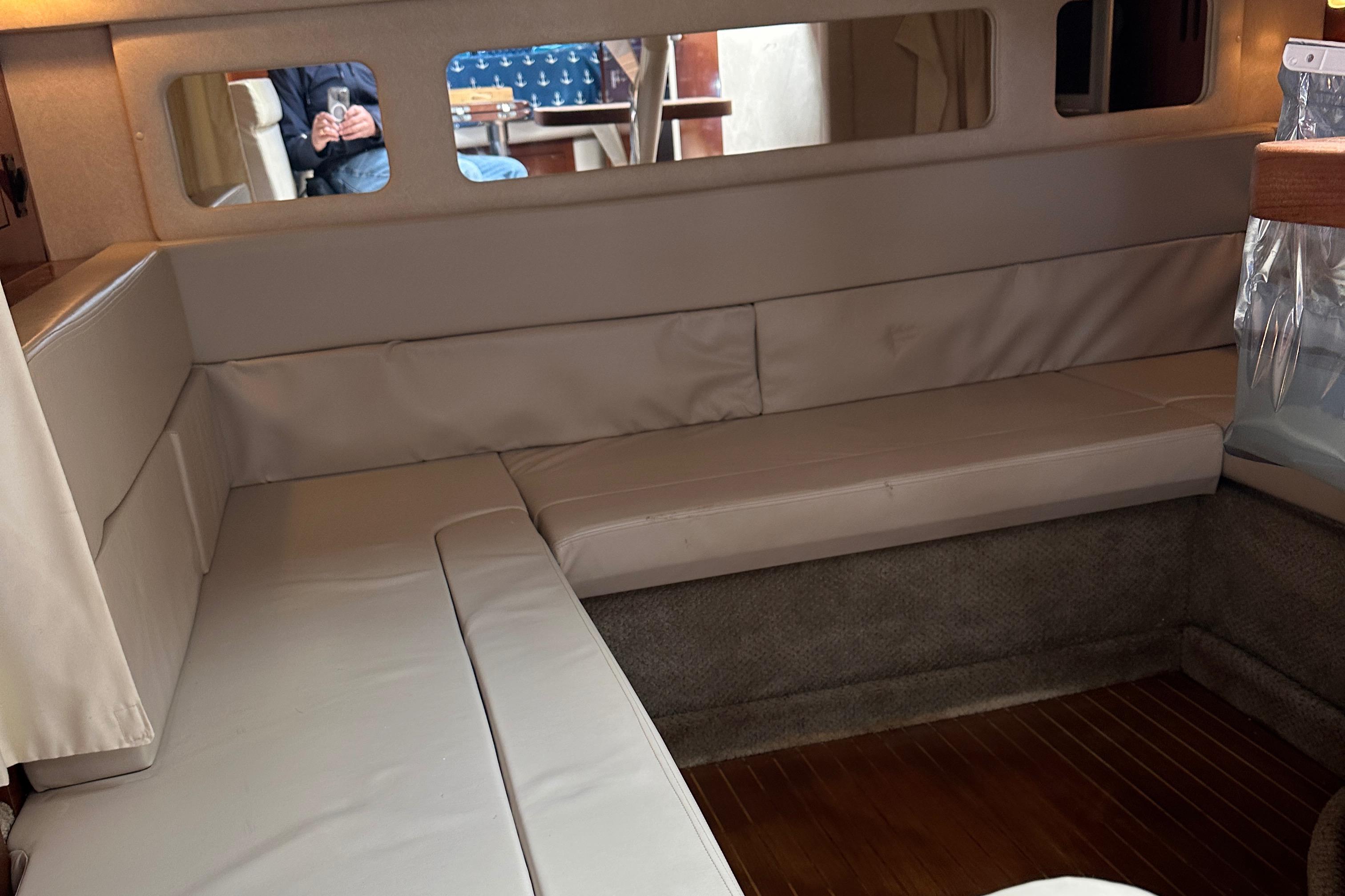 Interior seating area of 2008 Sea Ray 330 Sundancer yacht with white cushions.