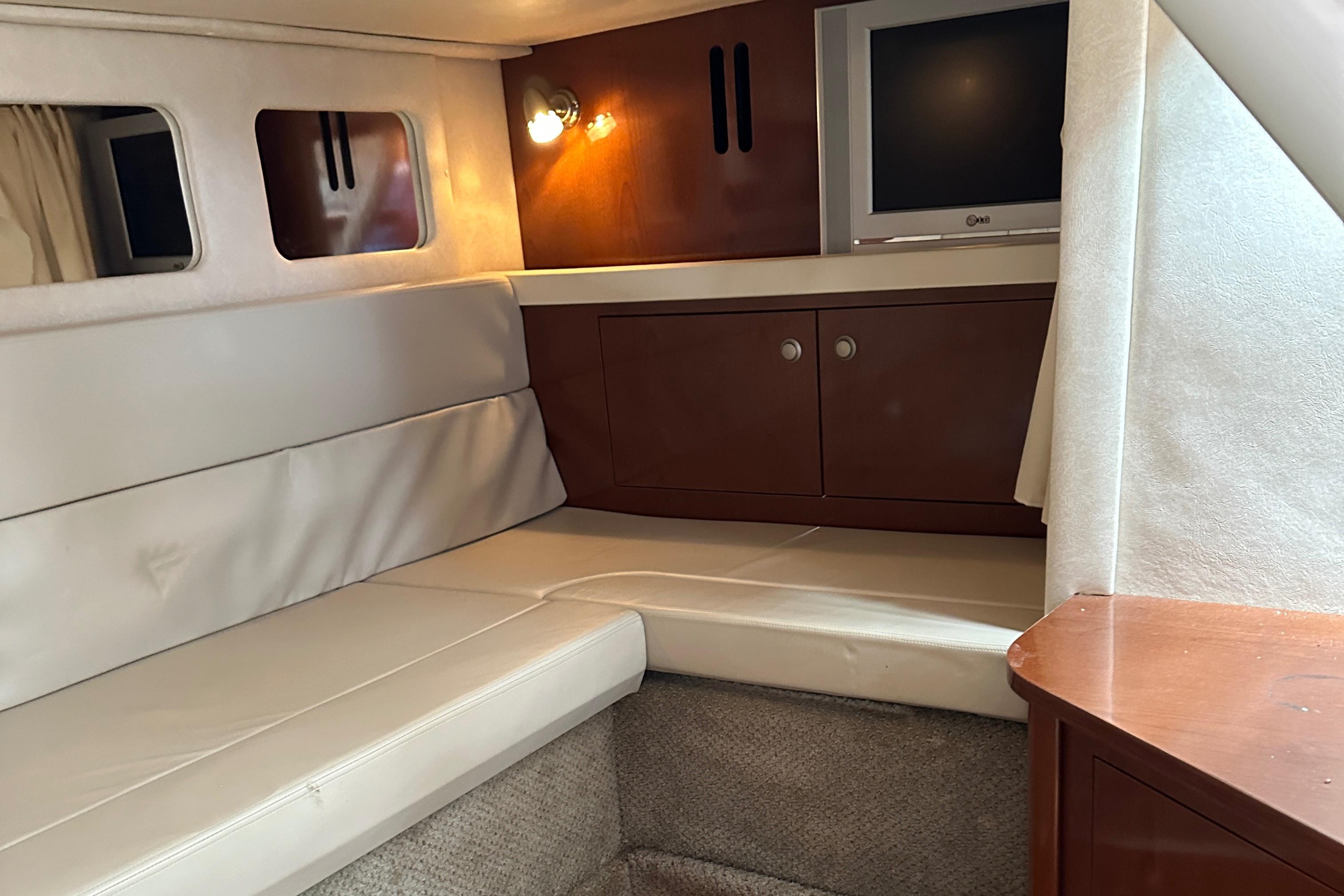 2008 Sea Ray 330 Sundancer cabin interior with seating, TV, and storage cabinets.