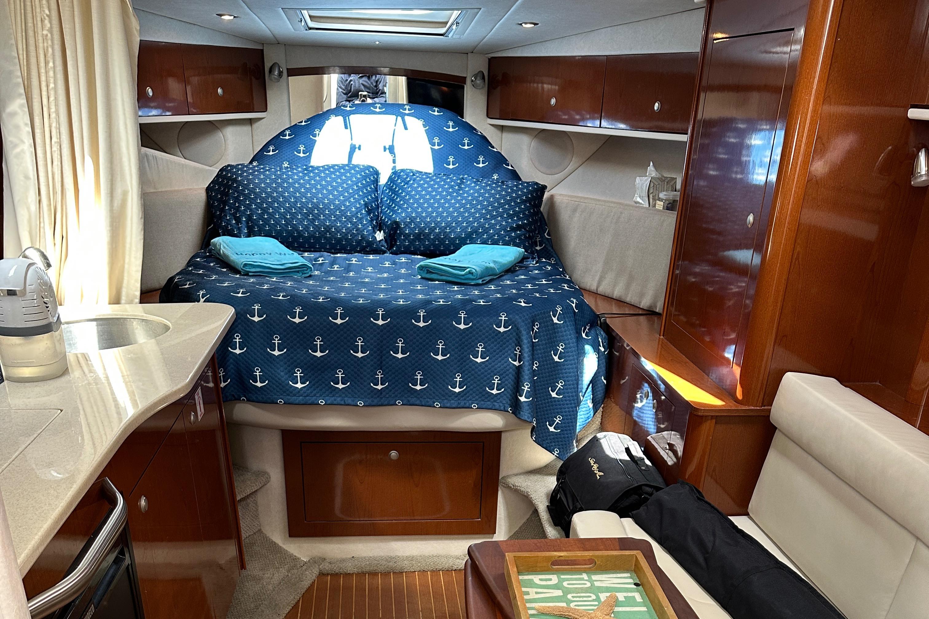 Interior of 2008 Sea Ray 330 Sundancer with cozy bed and nautical decor.