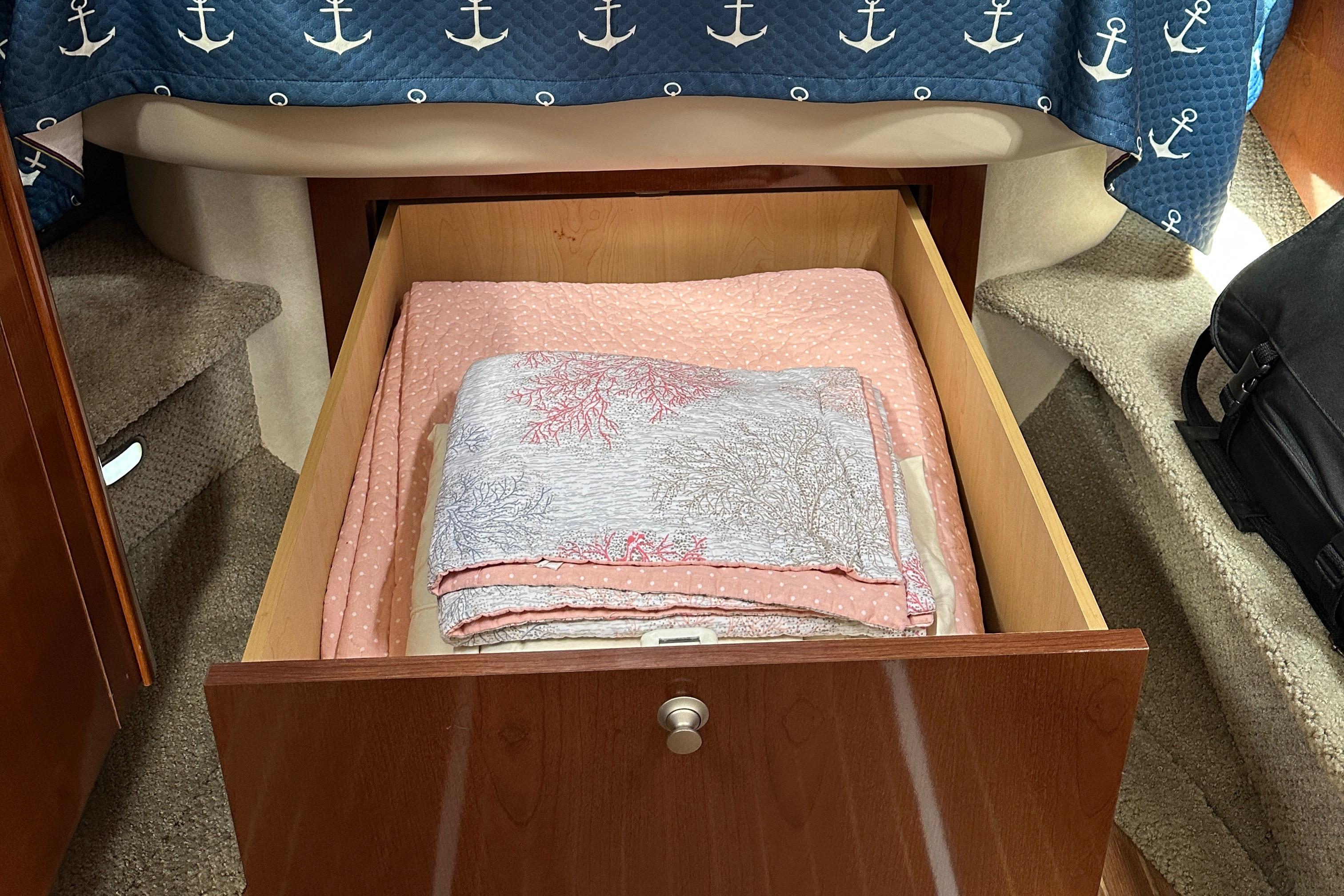 Open drawer with folded blankets inside a 2008 Sea Ray 330 Sundancer boat cabin.