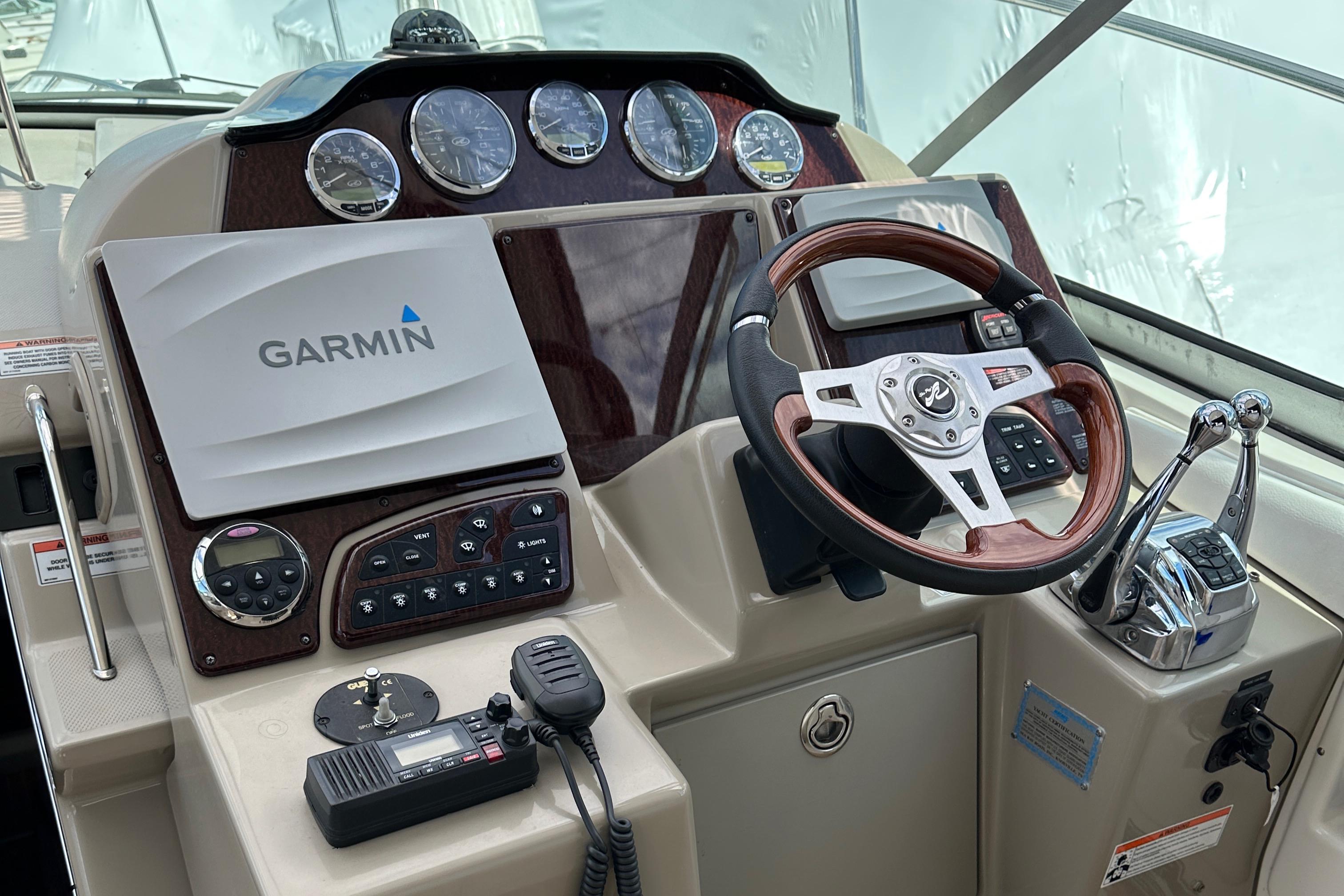 2008 Sea Ray 330 Sundancer helm with Garmin navigation and wood-accented steering wheel.