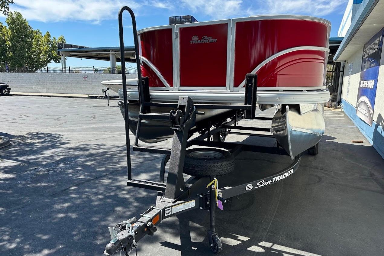 2026 Sun Tracker Party Barge 18 DLX pontoon boat on trailer, parked outdoors.